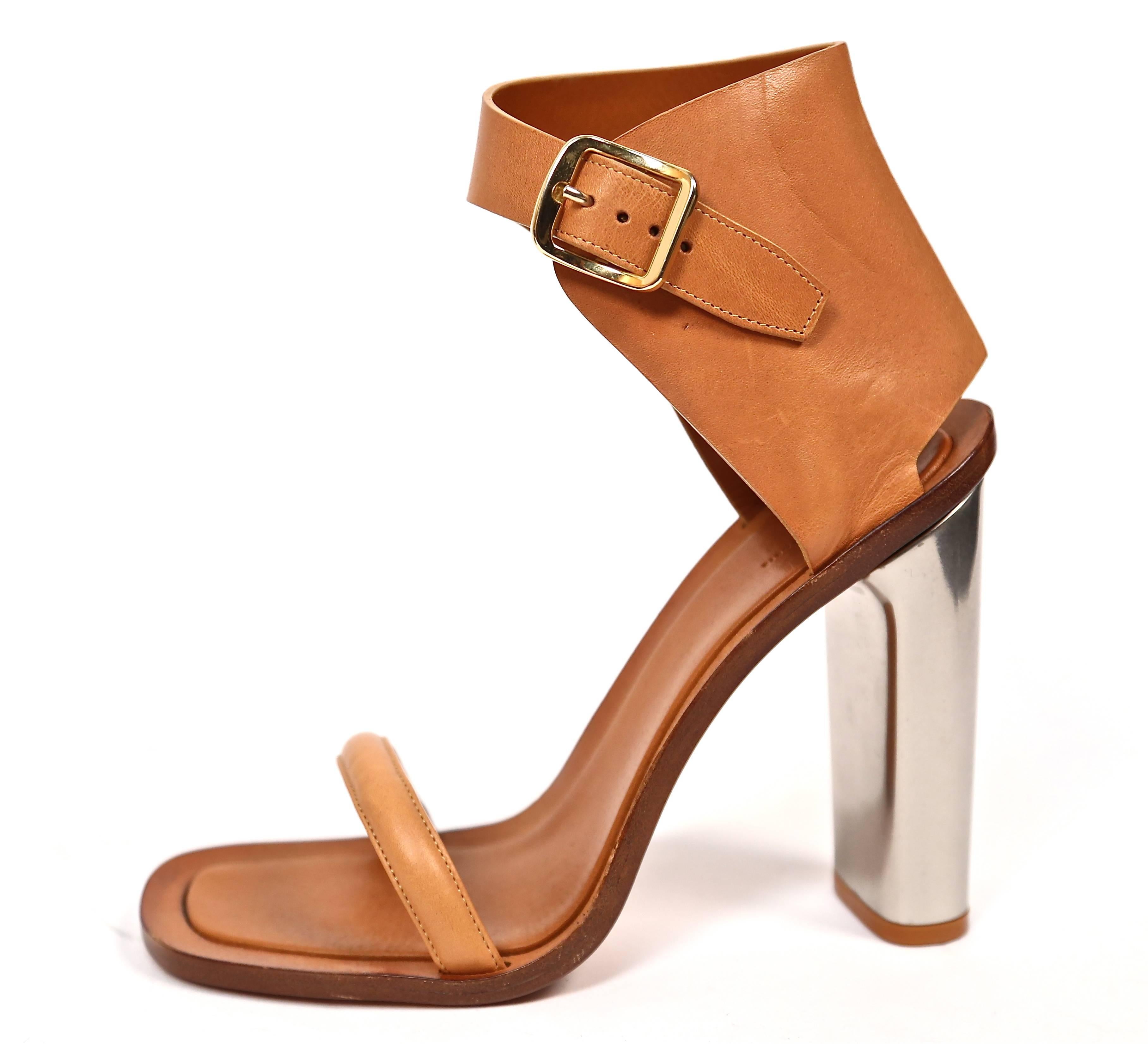 Tan leather bam bam sandals with silver metal heels from Celine. French size 40.5. Insoles measure approximately just under 10.5" long by 3.5" and heels are approximately 5"high. Leather soles, insoles and lining. Gold buckles at