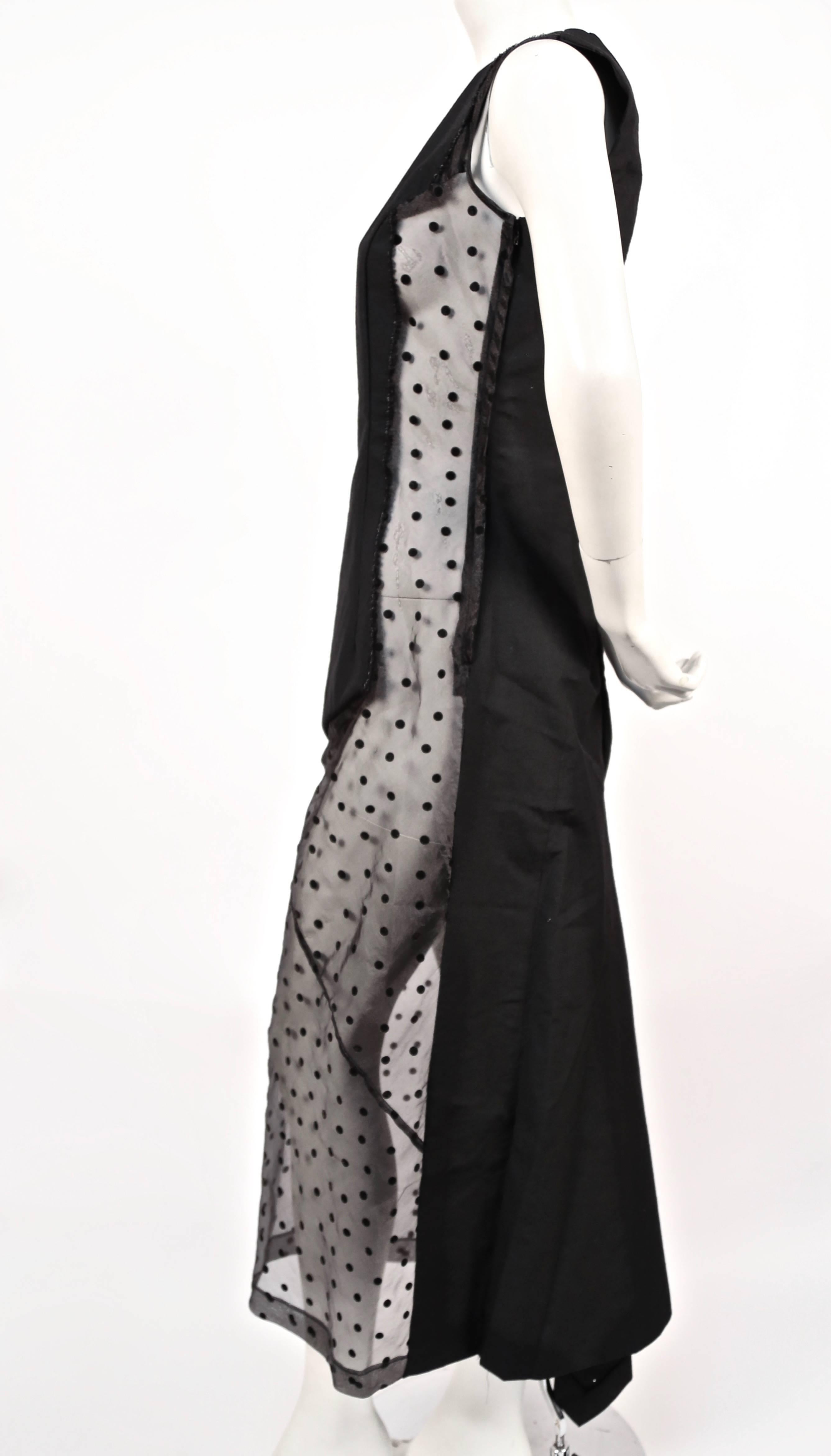Very rare black paneled dress with sheer black dotted tulle inserts and fishtail hemline from Comme Des Garcons dating to fall of 1997 as seen on the runway. Size 'M'. Approximate measurements: bust 34.5", waist 29.5", hips 37" and