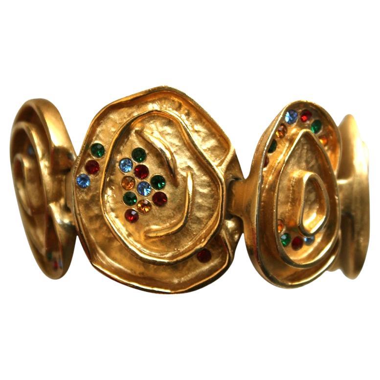 Very unique, organically shaped gilt link bracelet inlaid with small colorful faceted glass stones from Balenciaga dating to the 1980's. Asymmetrical in design. Fits a smaller wrist. Measures approximately 6.5