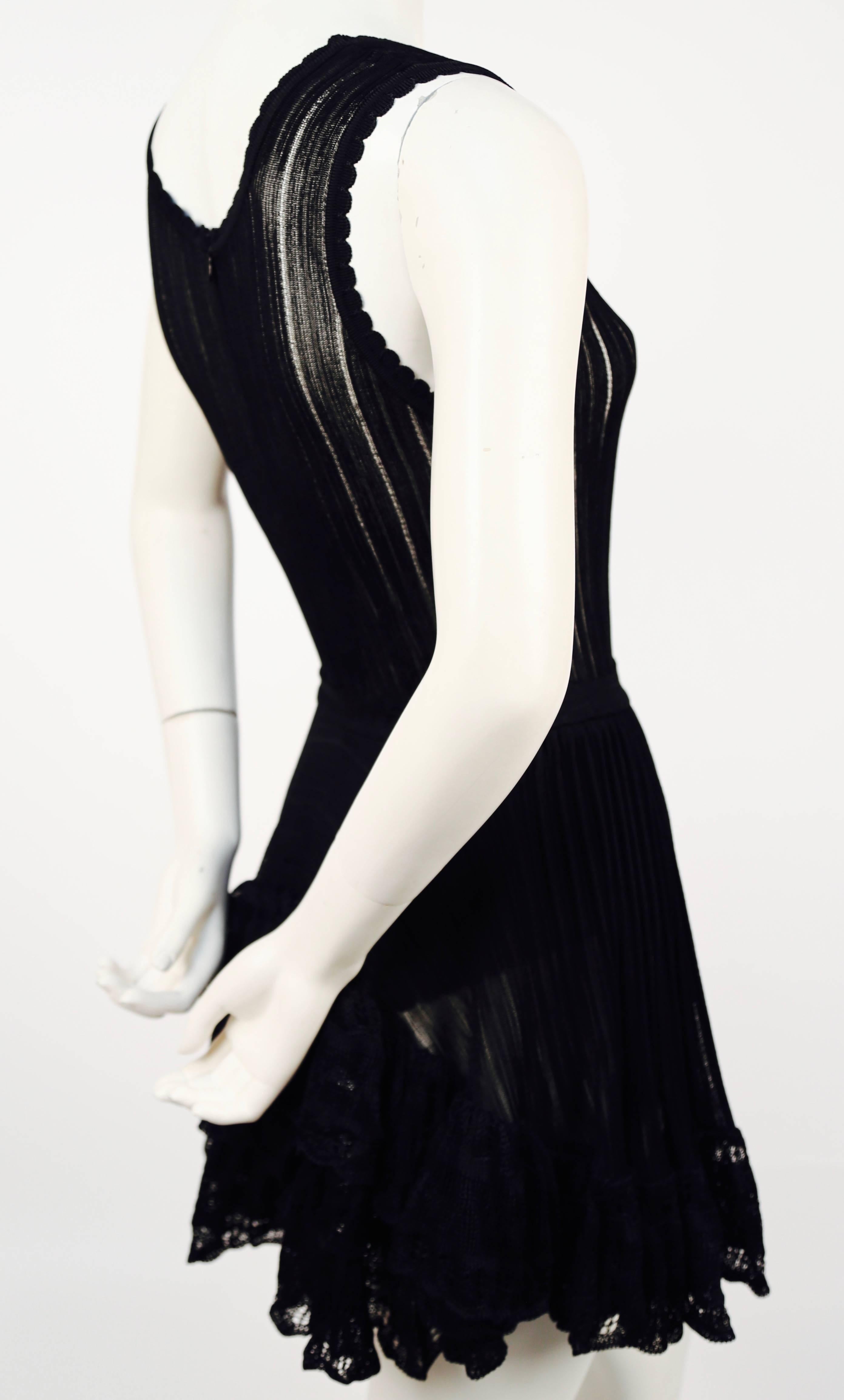 Black lace dress with bustle designed by Azzedine Alaia dating to the summer of 1992. Labeled a size M however this has been professionally shortened at the waist and would work best for a more petite woman. Approximate measurements (unstretched):