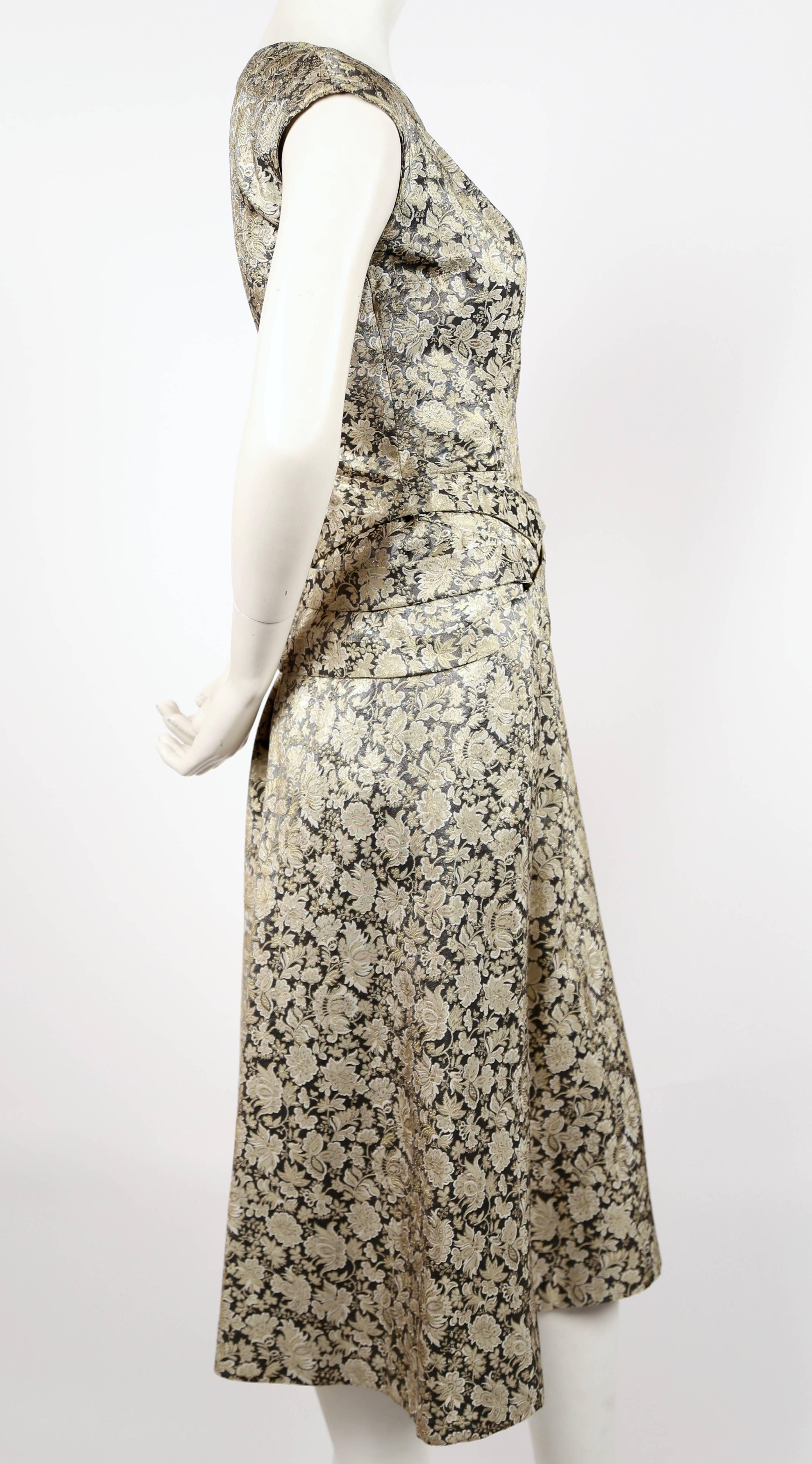Very rare silver metallic brocade haute couture dress with cross tie detail at waist designed by Antonio Castillo for Jeanne Lanvin dating to the 1950's. Dress best fits a US 6 to 8. Approximate measurements: bust 35, waist 29