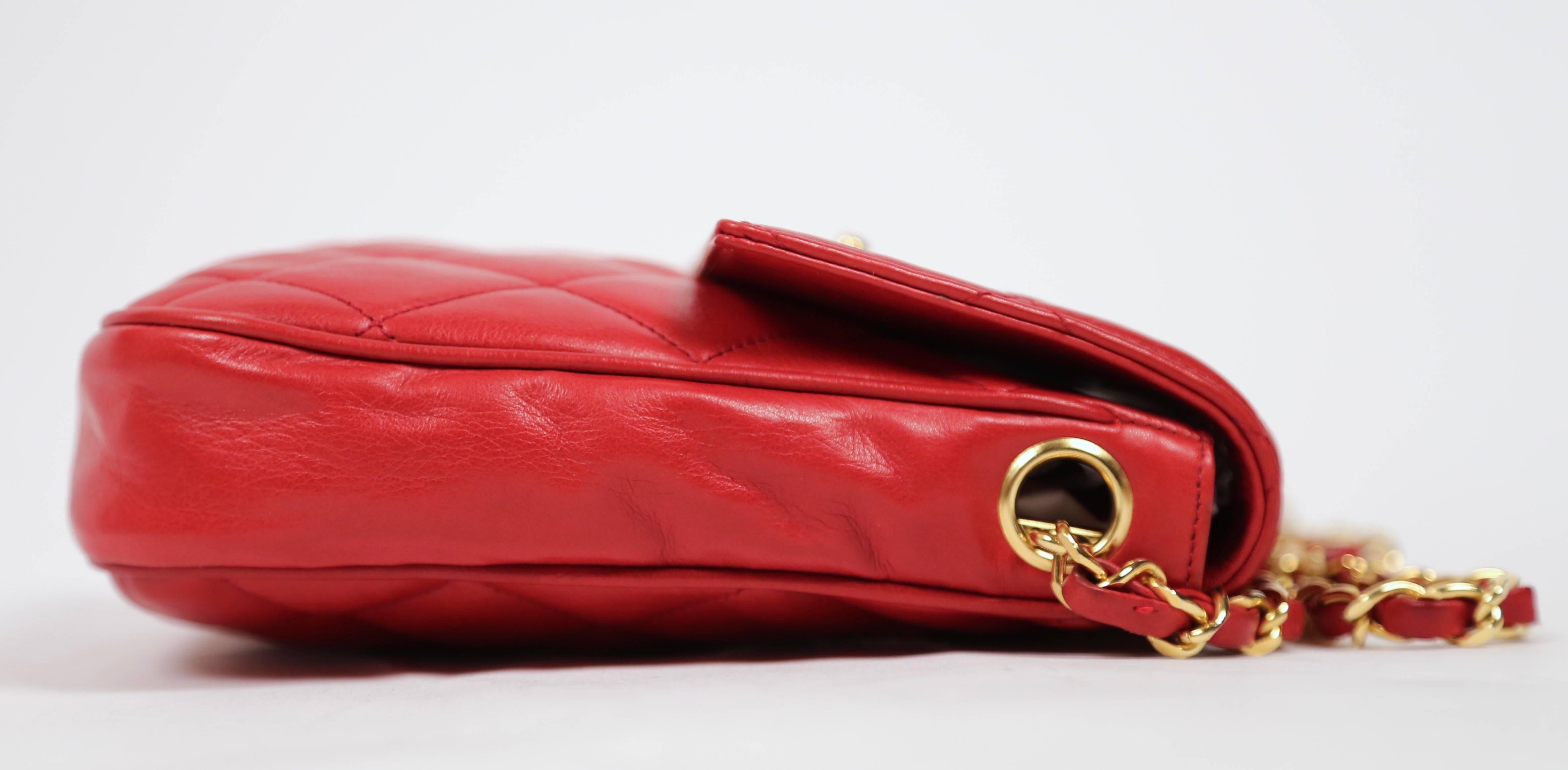 Vivid red butter soft leather satchel style bag by Chanel circa 1986-88. Approximate measurements: 7" x 7" x 1.75". Shoulder strap which can be worn crossbody on a petite frame. Strap has a drop 17" (34" total length). Very