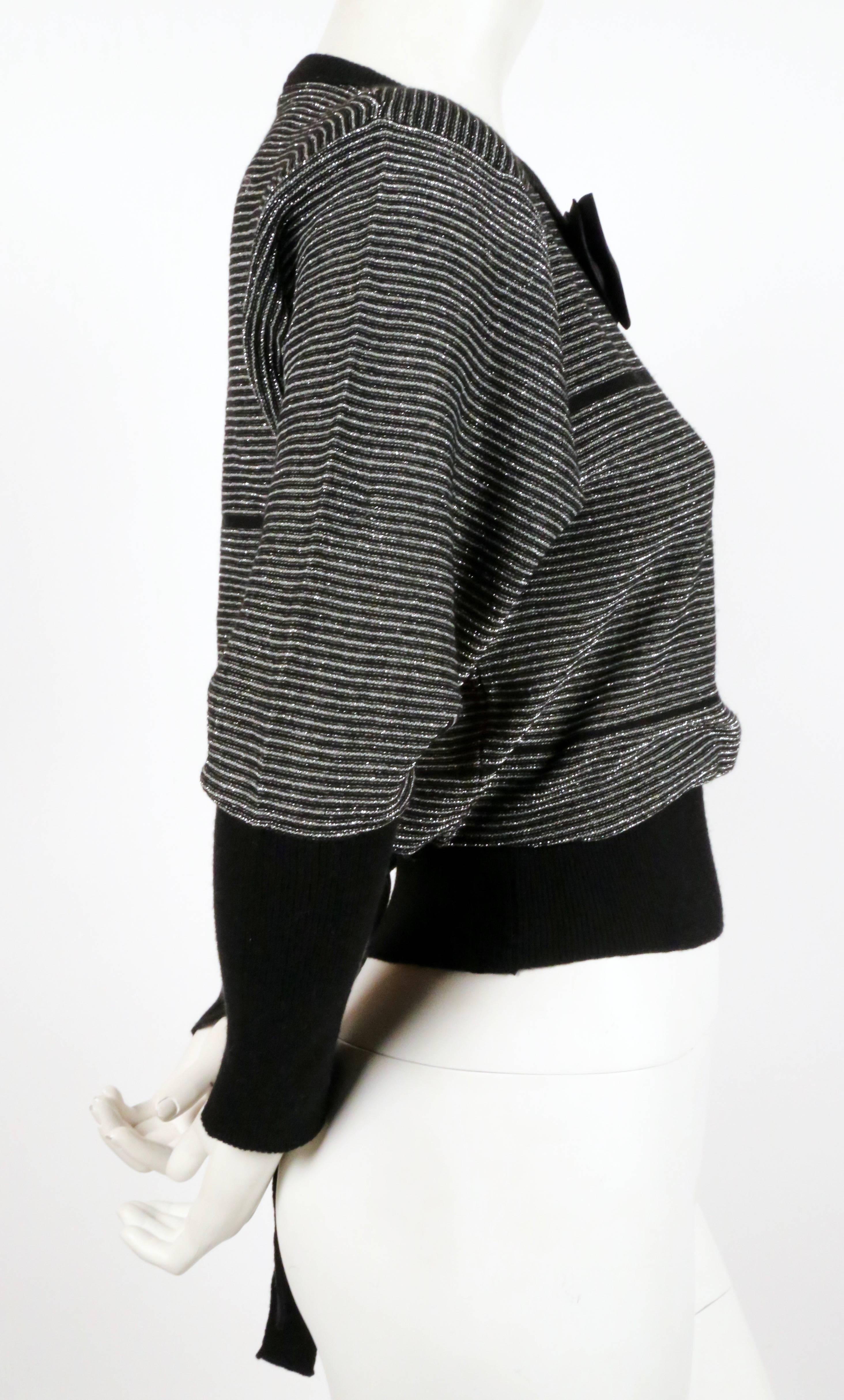 Black and silver lurex striped sweater with satin bowtie designed by Sonia Rykiel dating to the 1970's. Labeled a French size 36. Approximate unstretched measurements: shoulder 17
