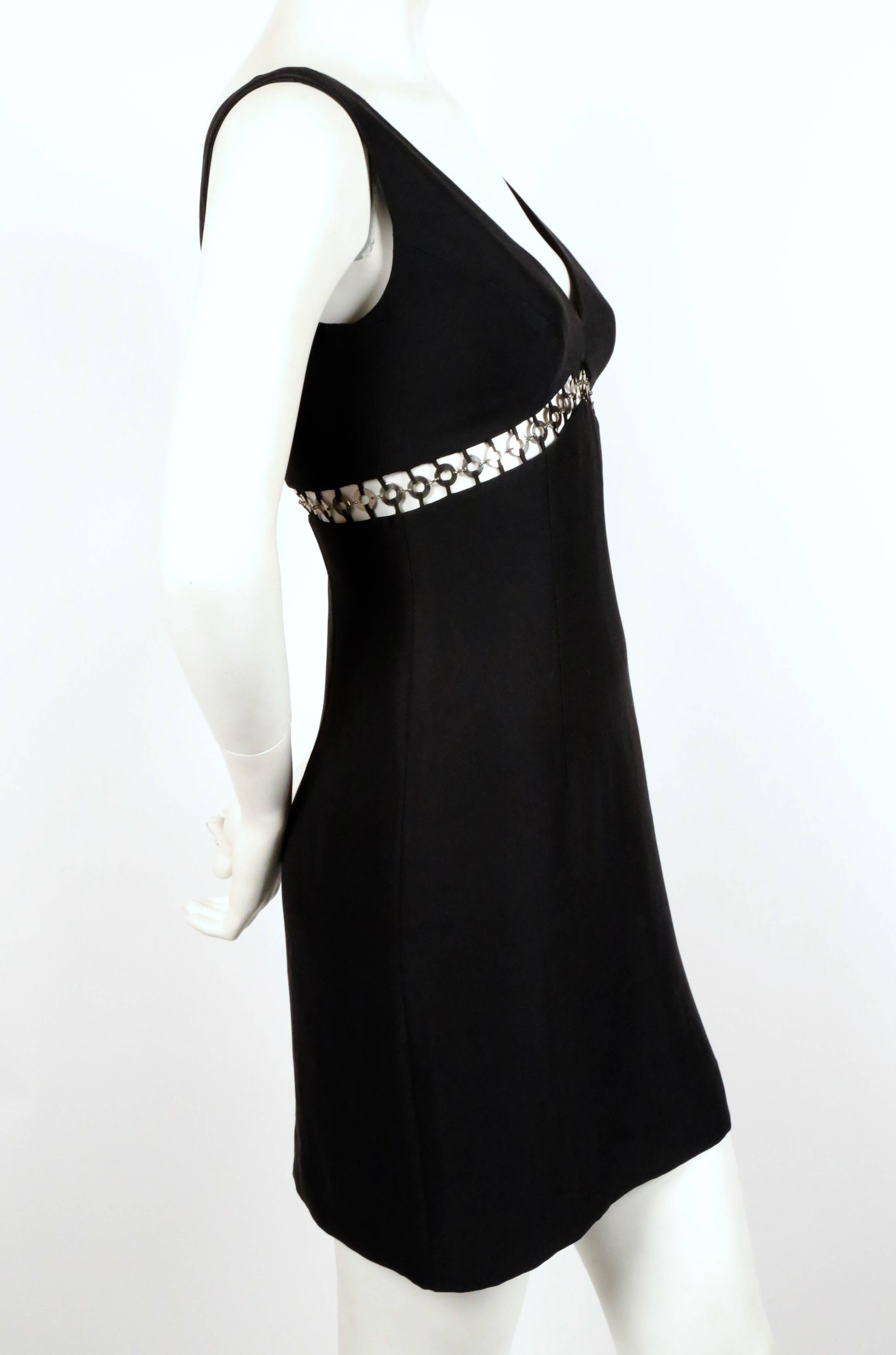 Jet black mini dress with cut out and silver metallic rings from Sophie Sitbon dating to the 1990's. Best fits a US 2. Approximate measurements: bust 32