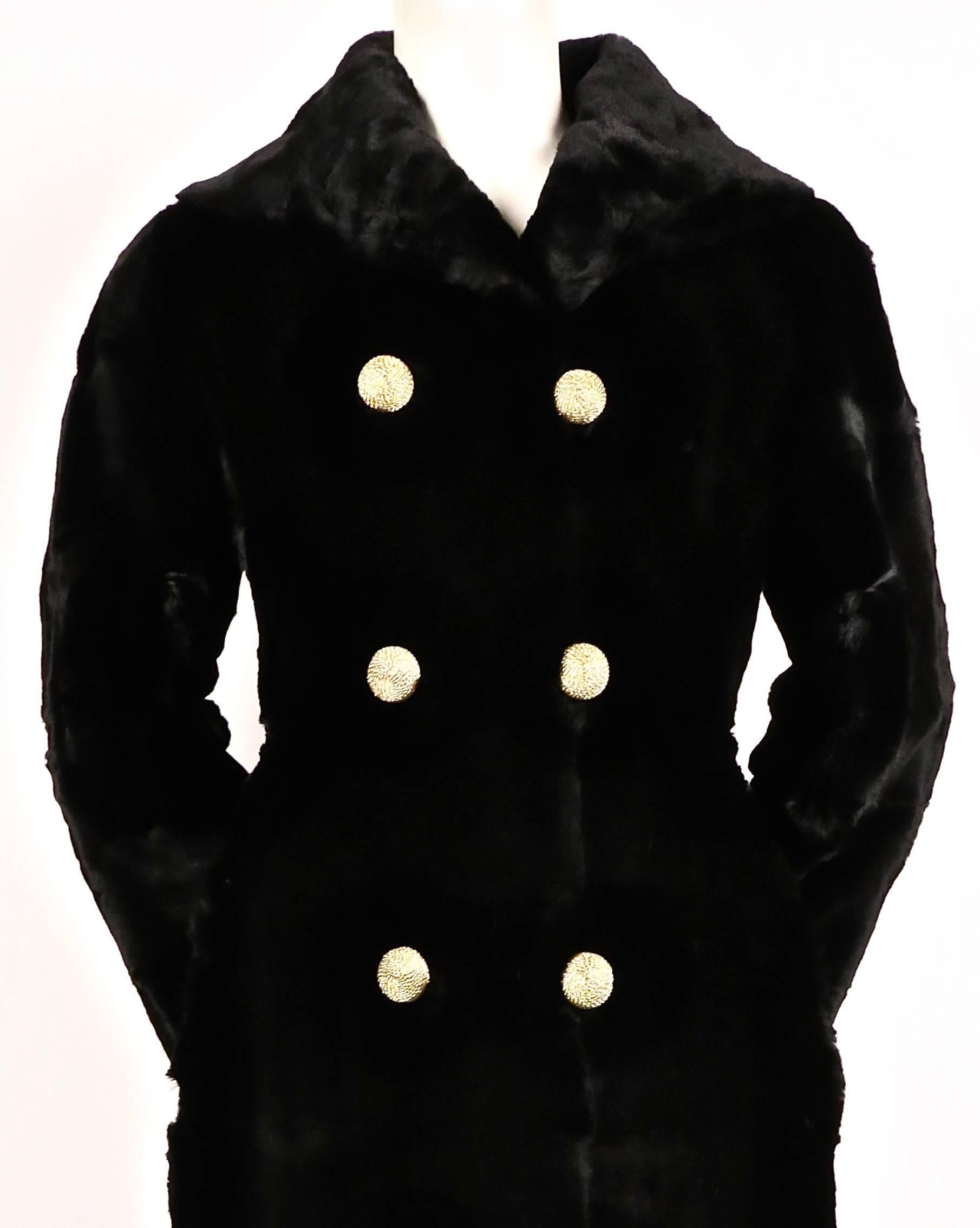Sheared, black, seal fur, full length coat with gold buttons designed by Revillon for Saks Fifth Avenue dating to the 1960's. Fits a US size 2 or 4. Coat measures 33