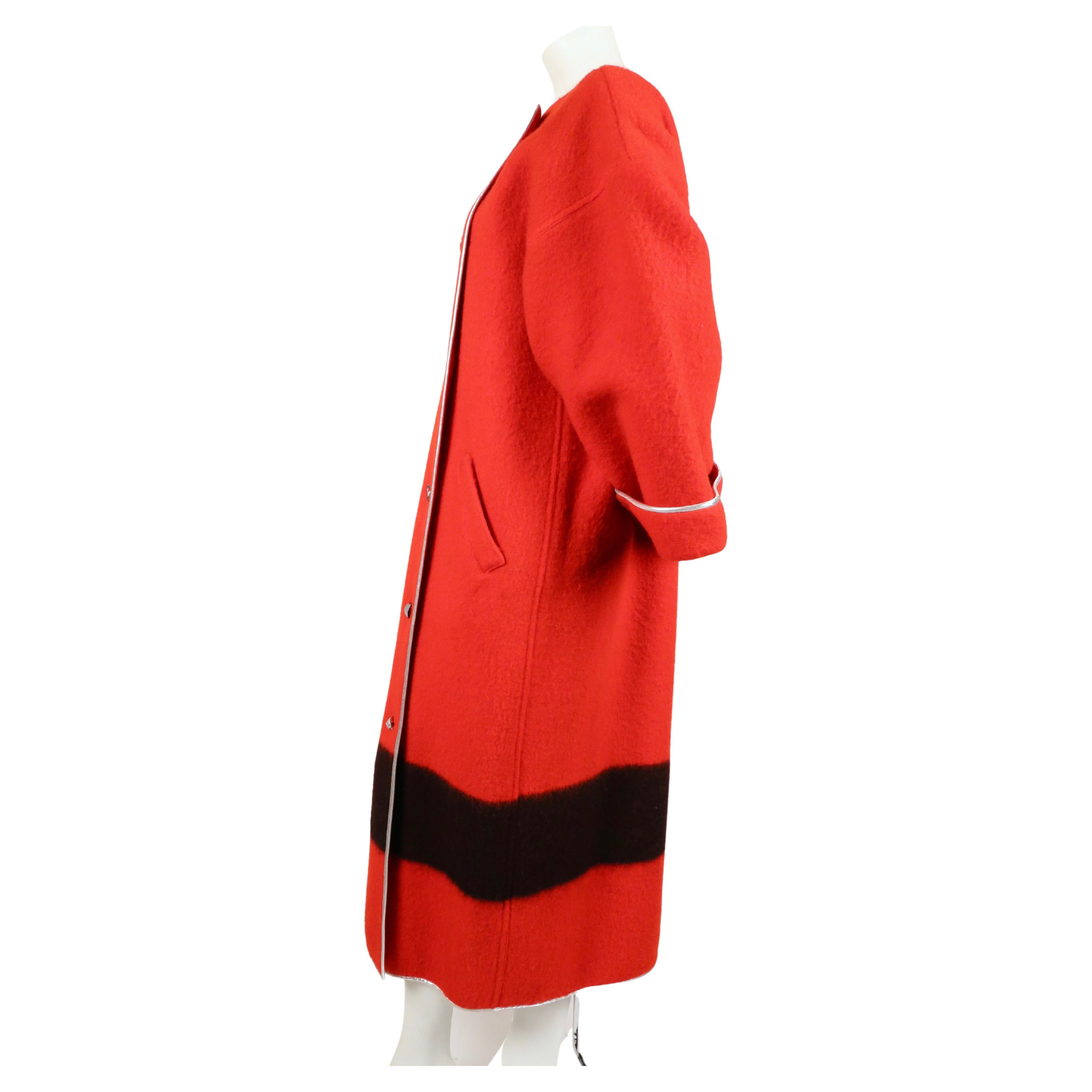 Unique red blanket coat with black stripe, silver piping and unique faceted buttons from Geoffrey Beene dating to the 1980's. Labeled a U.S. size 6 however it can fit many sizes to the oversized cut. Measure approximately: 23