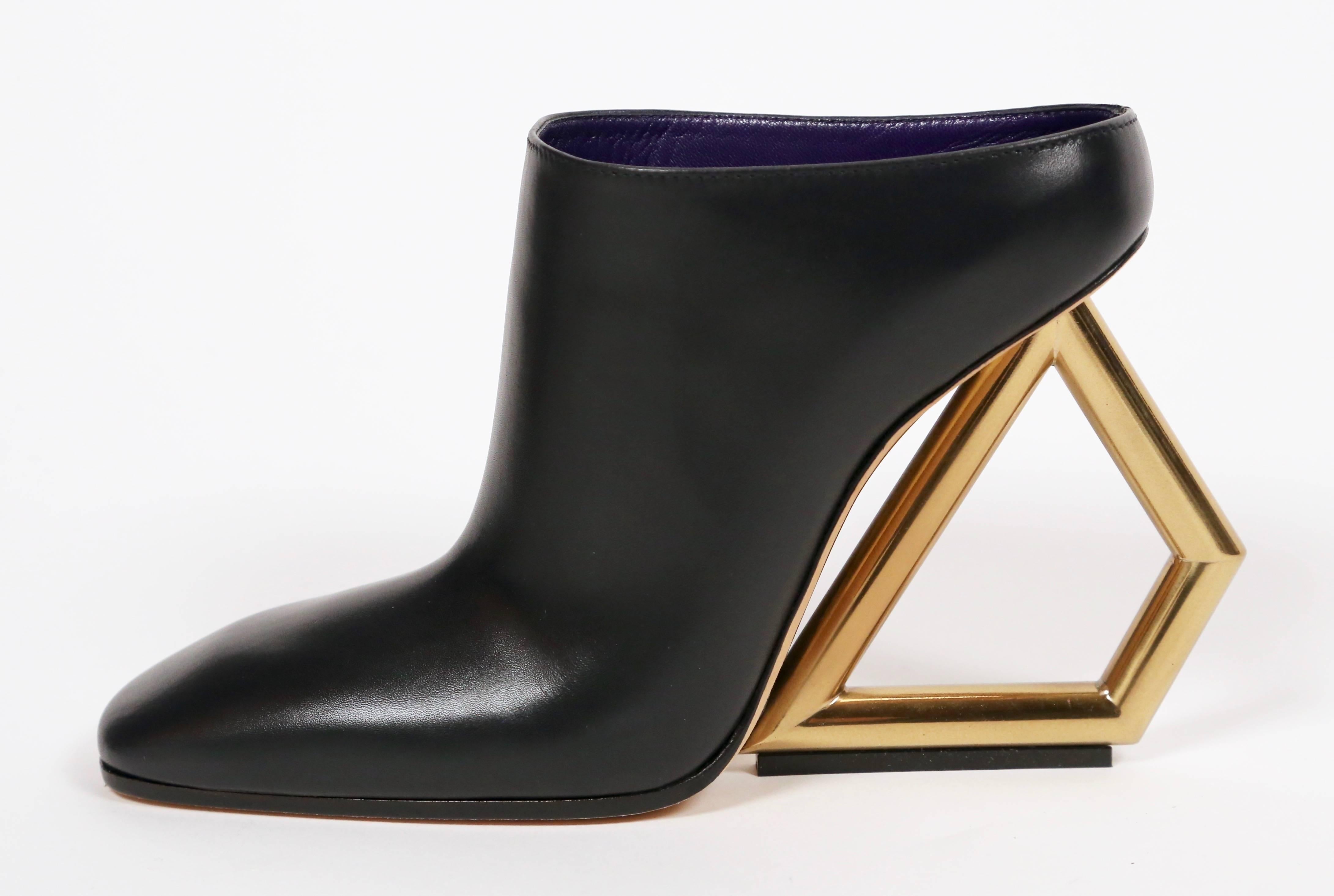 Unworn, black leather mules with gold toned trapezoid heels from Celine as seen on the runway in spring of 2014. French size 38. Insoles measure approximately just under 10.25