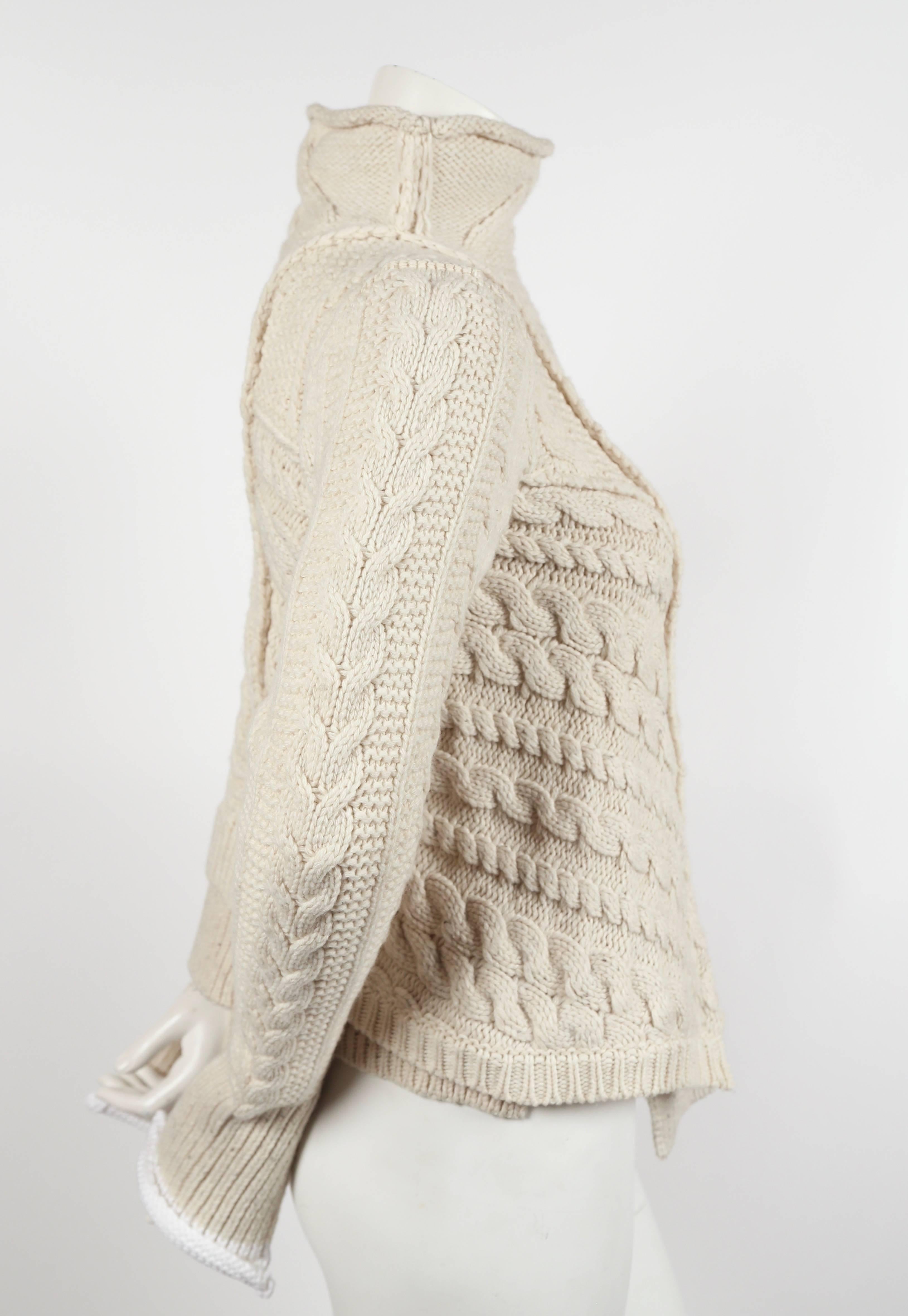 Very rare cream cable knit sweater with asymmetric hemline designed by Phoebe Philo for Celine dating to Fall of 2011. Labeled a size 'S'. Fits a size extra-small or small. Approximate measurements (unstretched): shoulder 14