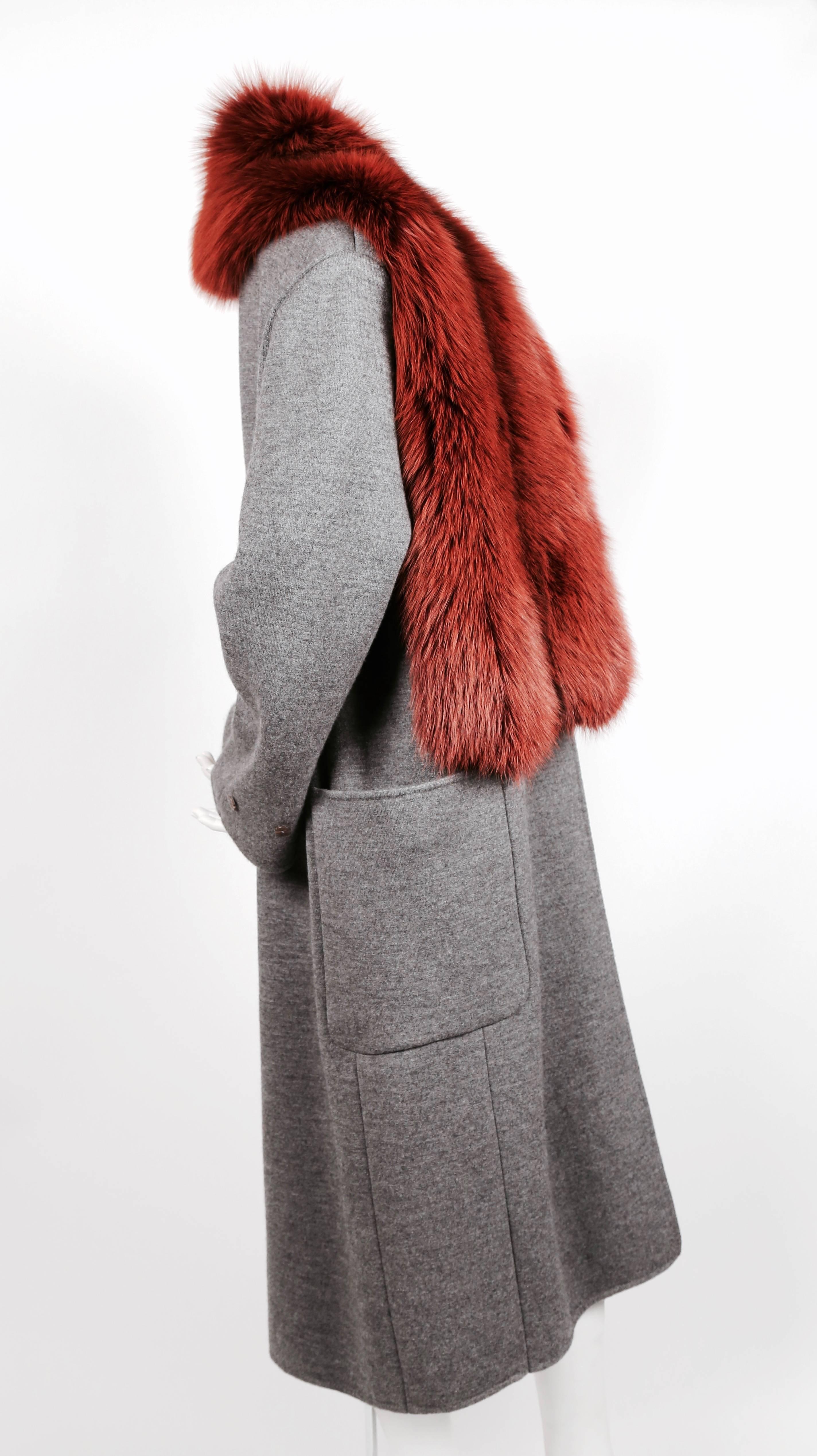 Exceptional grey wool, silk and cashmere blend coat with wrap around pockets, contrasting trim, button details and lush dyed fox fur collar designed by Phoebe Philo for Celine. French size 36. However, this coat has an oversized fit so it can fit