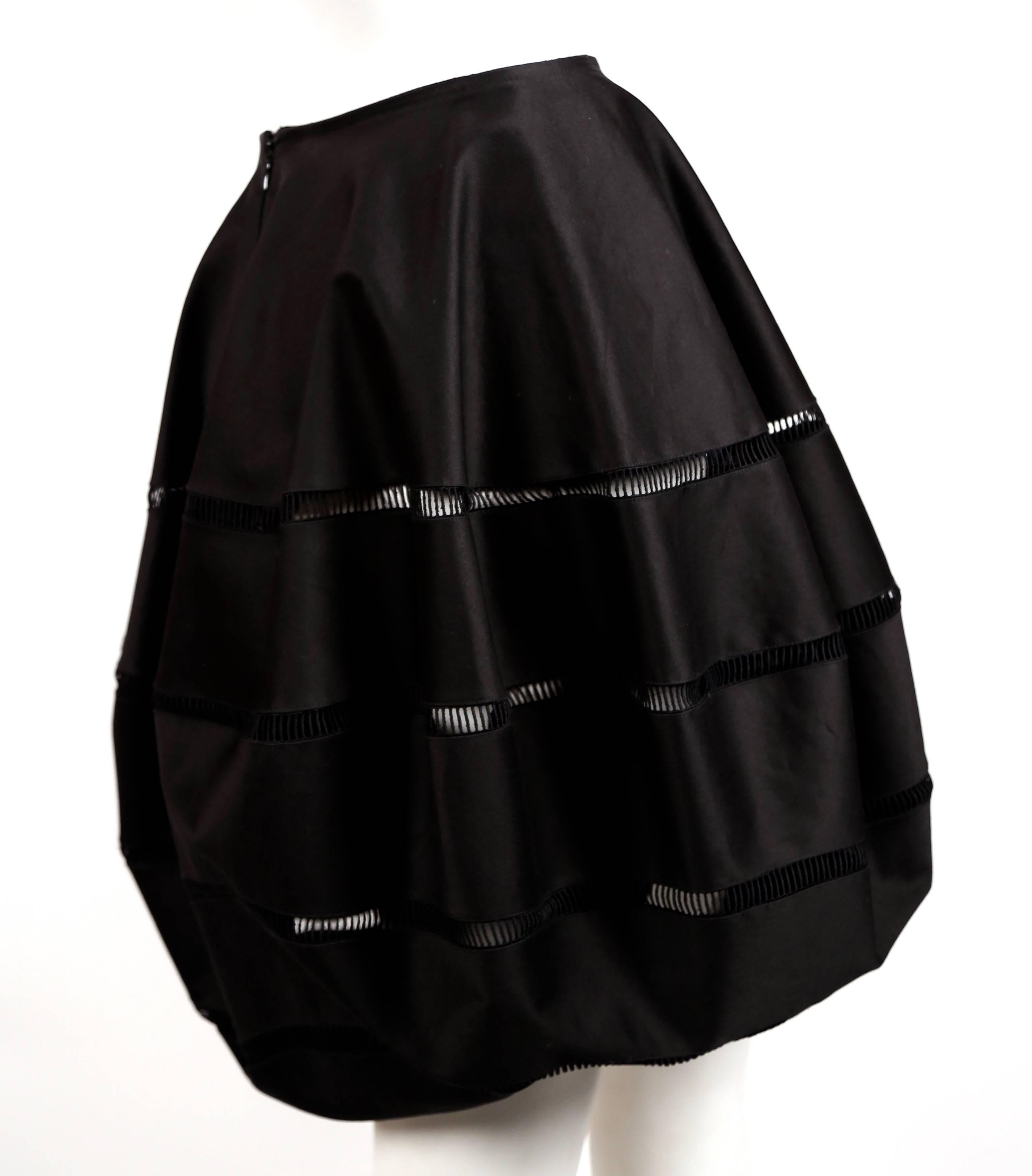 Black polished cotton bubble skirt with embroidered cut outs designed by Azzedine Alaia. Best fits a US size 2-4. Approximate measurements: waist laying flat 25