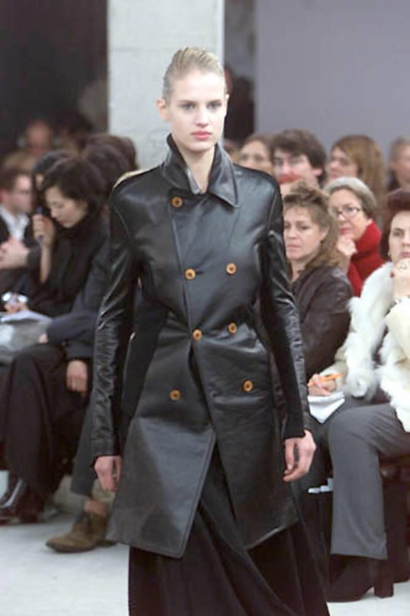 Very unique, jet black leather jacket with knit back with unique shaped amber buttons from Comme Des Garcons dating to fall of 2002. As seen on the runway (in longer length). Labeled size 'S'. The jacket is best suited for an XS or S. Made in Japan.