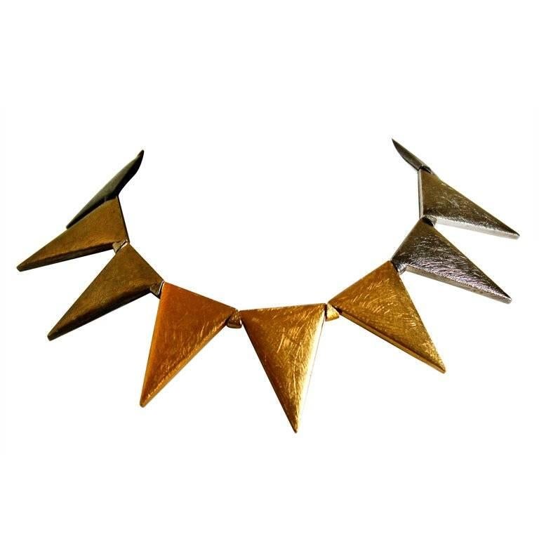 Textured gold, silver and gunmetal triangular link necklace from Yves Saint Laurent dating to the late 1980's, early 1990's.  Numbered 34 out of 100. Adjustable hook closure. Excellent condition.