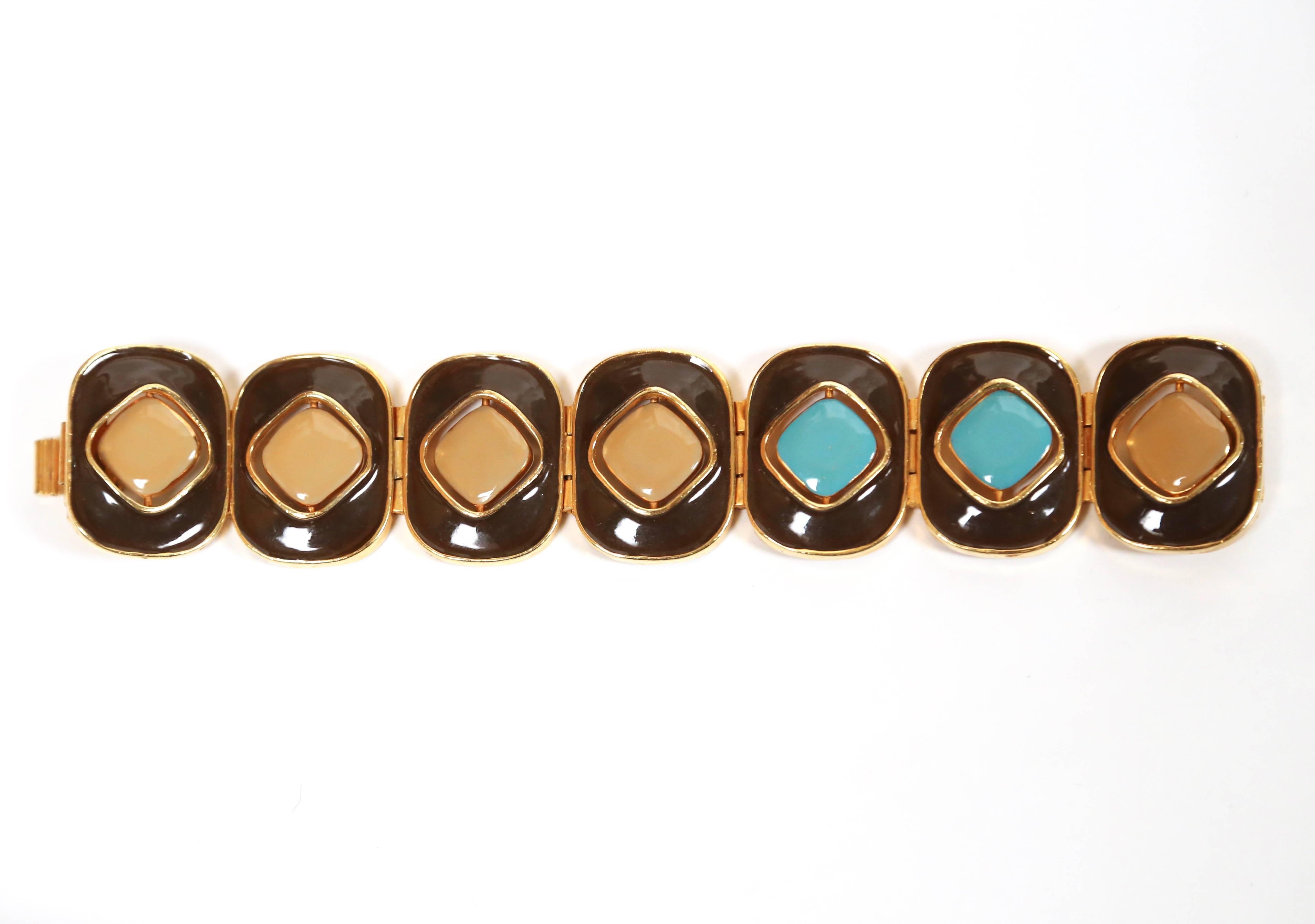 Very rare enameled brown gilt bracelet with reversible accents from Pierre Cardin dating to the 1960's. Measures approximately: 1.5" wide by 7" long. Fits a small to medium wrist. Enameled pieces reverse so that bracelet can be worn with