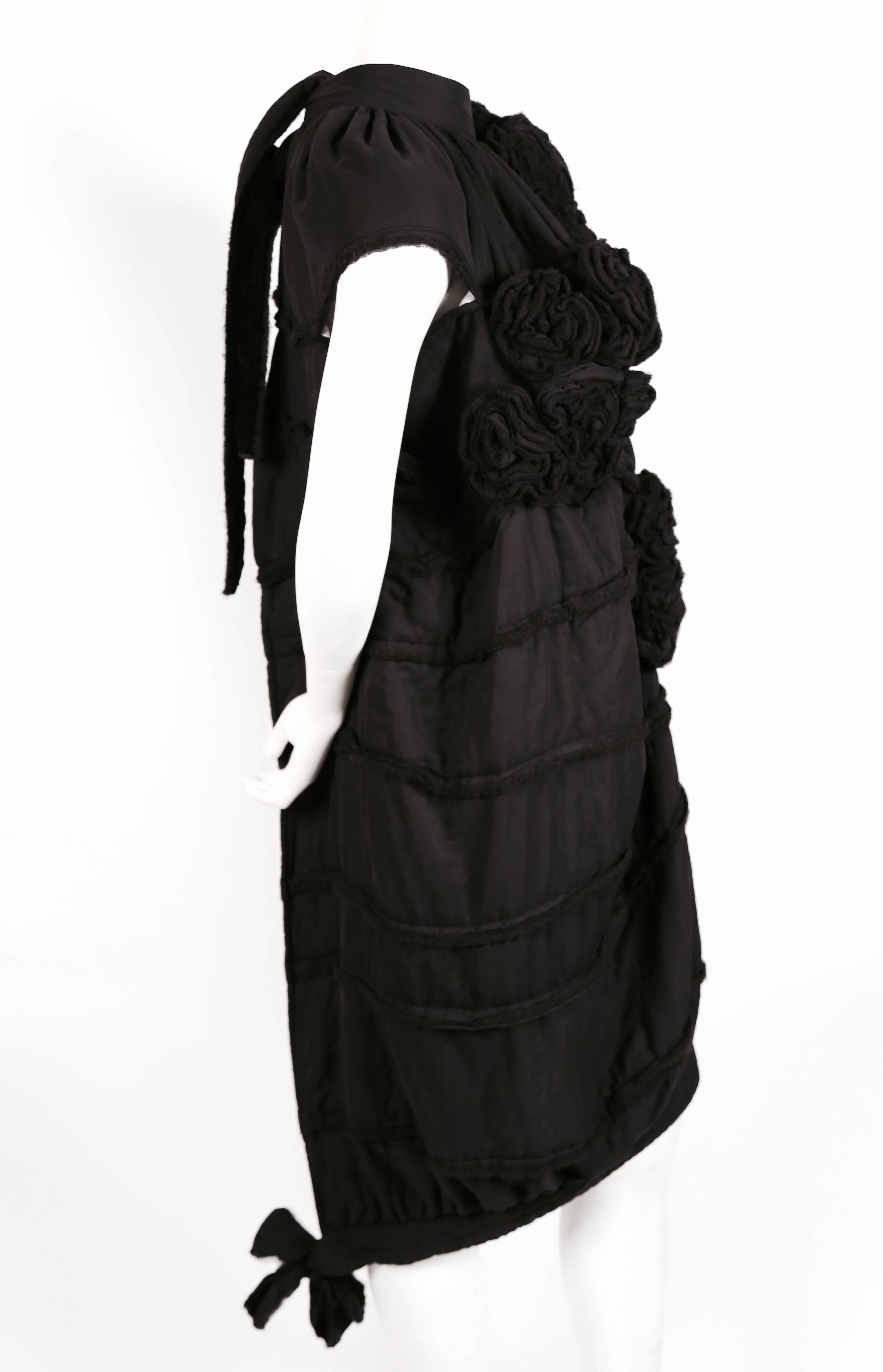 Very unusual, black, lightly padded dress with rosettes and unfinished edges designed by Tao Kurihara for Comme Des Garcons dating to fall of 2006. Size 'S'.  Measures approximately 37" at shortest point and 47" at longest point. Secures