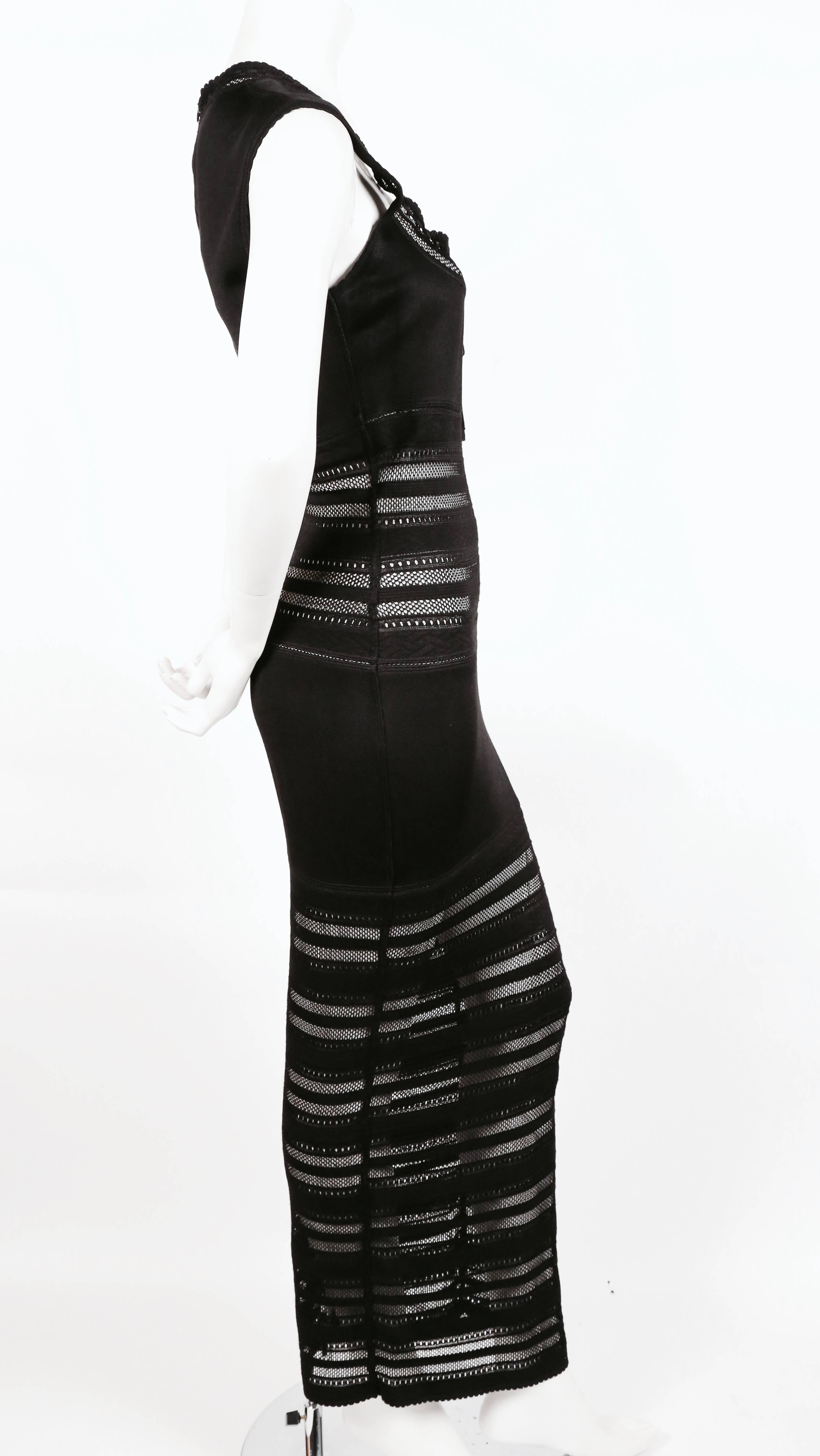 Very rare jet black long dress with open lace knit panels and adjustable neckline from Azzedine Alaia dating to 1993. Labeled a size 'XS' however this dress would best fit a modern medium or a broad shouldered size small. Approximate measurements: