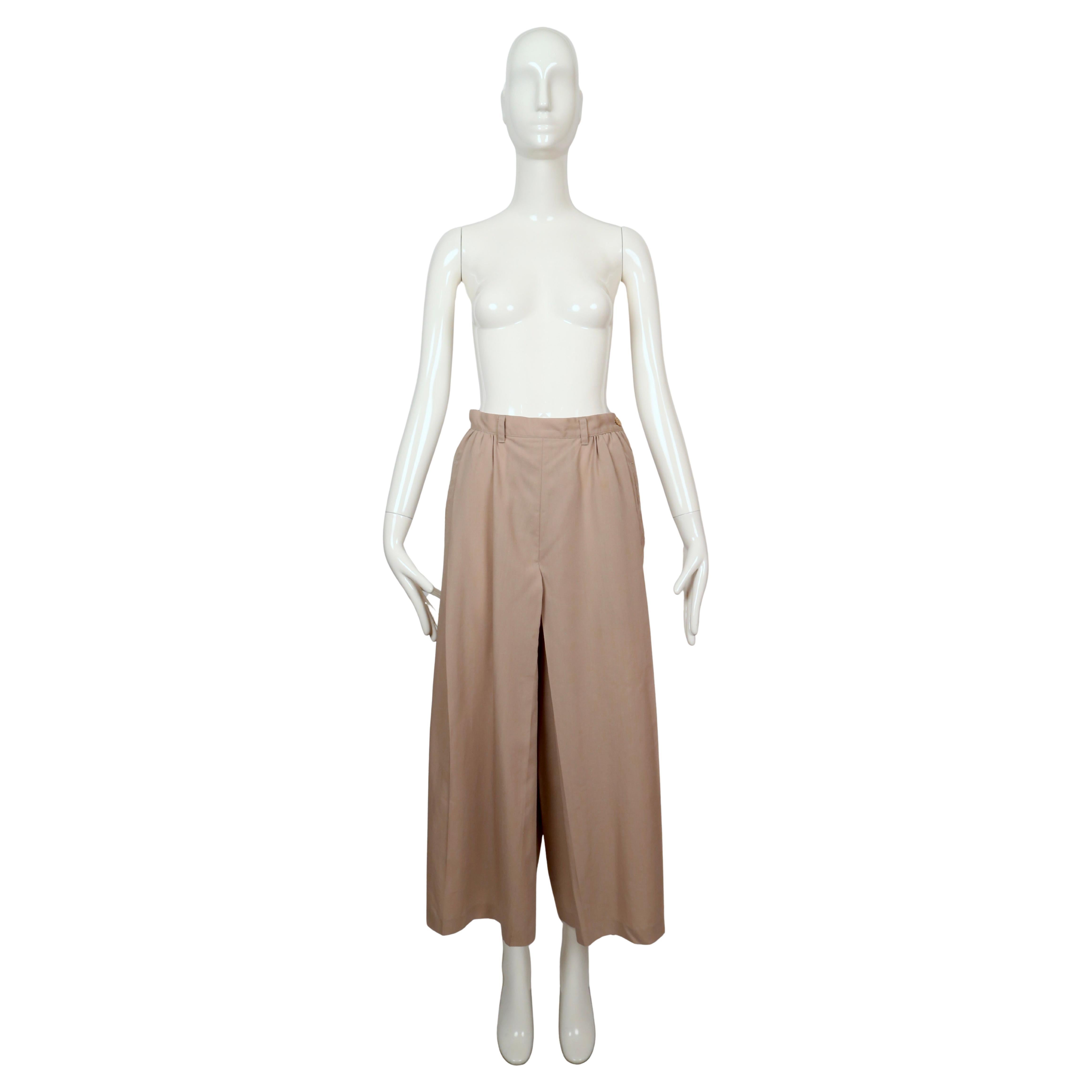 Pantaloni a gamba larga in lana tropicale degli anni '80 disegnati da Yohji Yamamoto, abilmente tagliati per assomigliare a una gonna quando vengono indossati. Progettato con morbide pieghe in vita per dare volume e movimento e rifinito con pratiche
