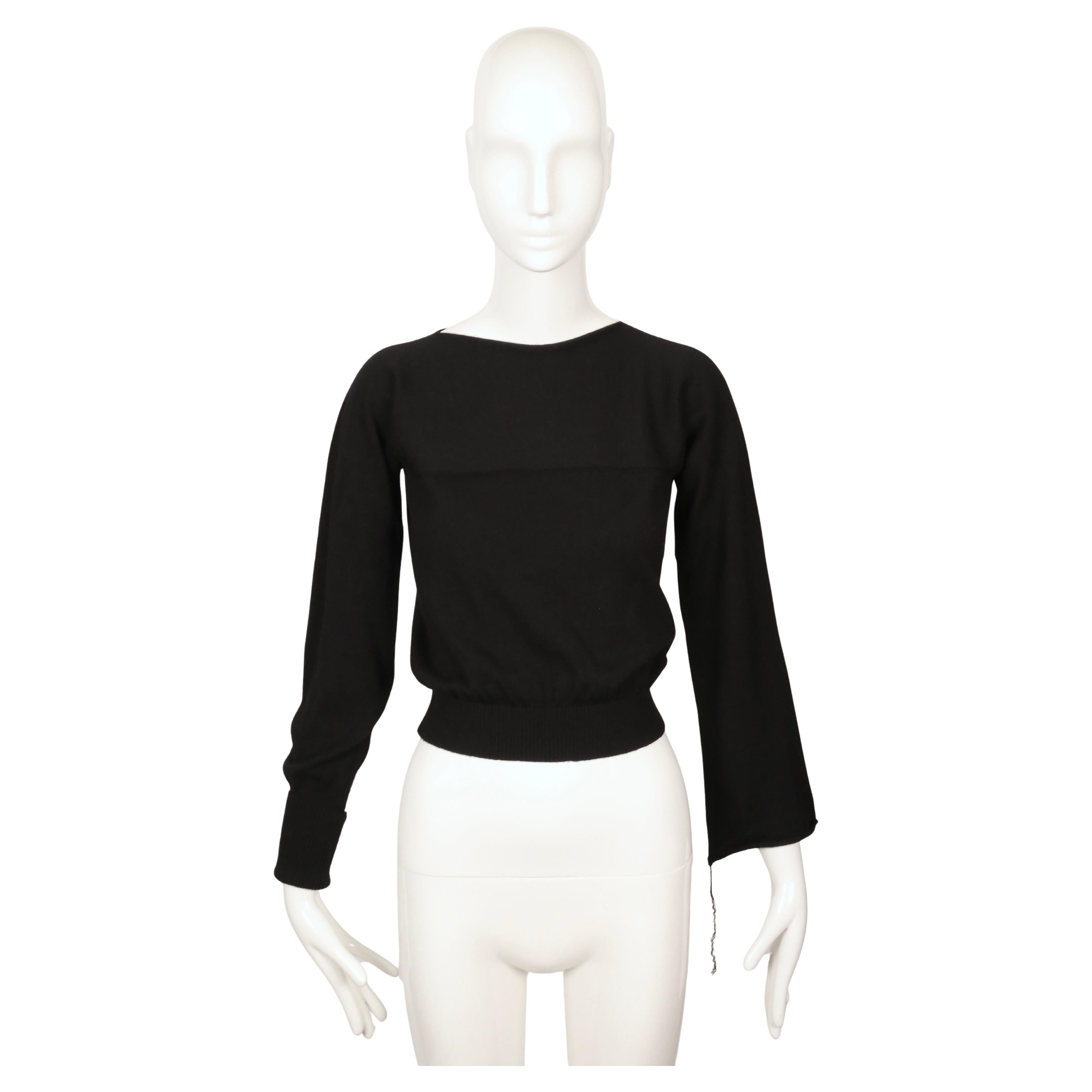 Pull minimaliste en laine vierge noire de fine épaisseur, issu de la collection automne 1997 de Martin Margiela. Le pull présente une large encolure, des coutures épaules tombantes, des manches asymétriques et une silhouette subtilement raccourcie