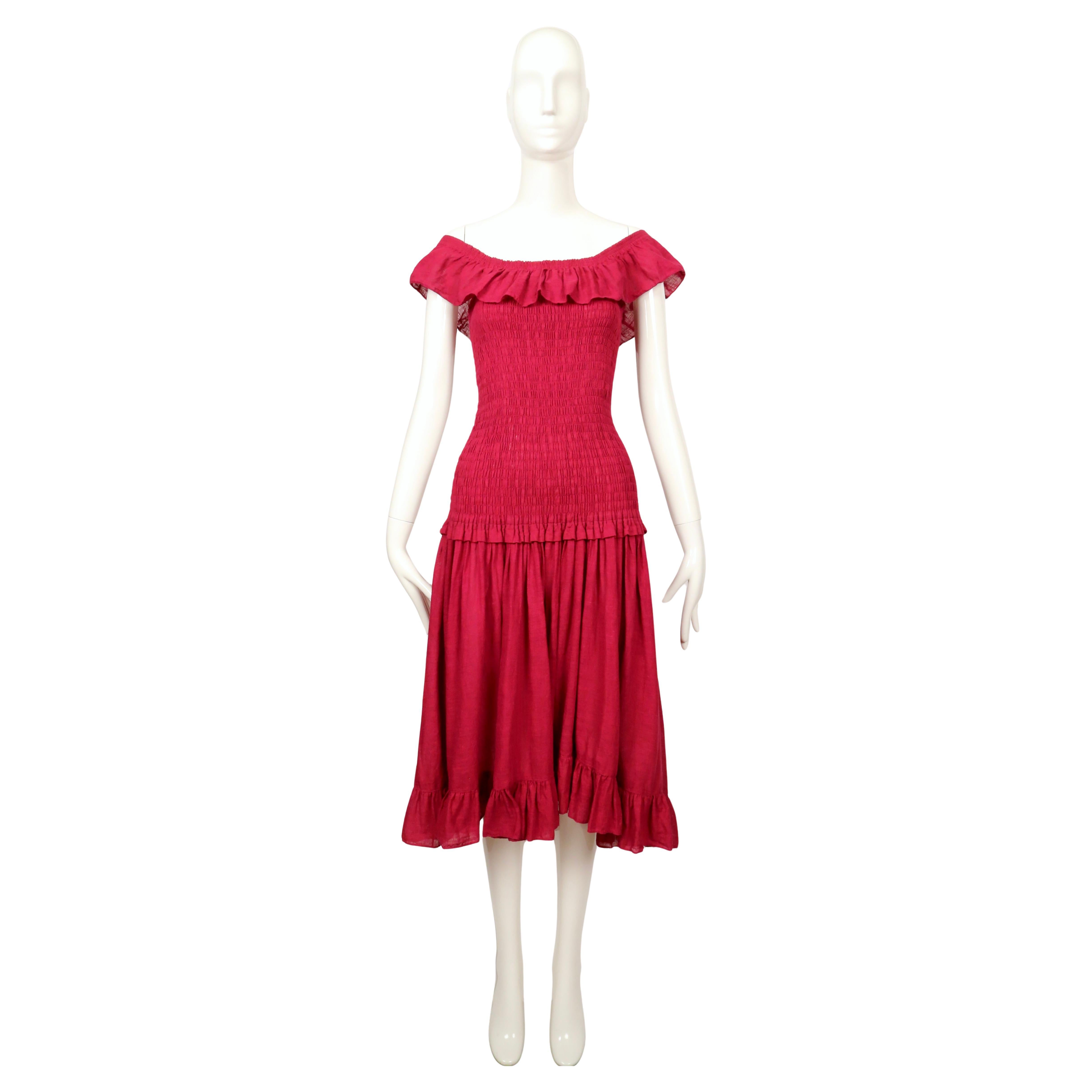 Dieses Kleid von Saint Laurent aus dem Jahr 1978 ist aus luftiger Baumwollgaze in einem satten Beerenrot gefertigt. Das Kleid hat einen weiten, gerüschten Ausschnitt, der sowohl schulterfrei als auch schulterfrei getragen werden kann. Das Mieder ist