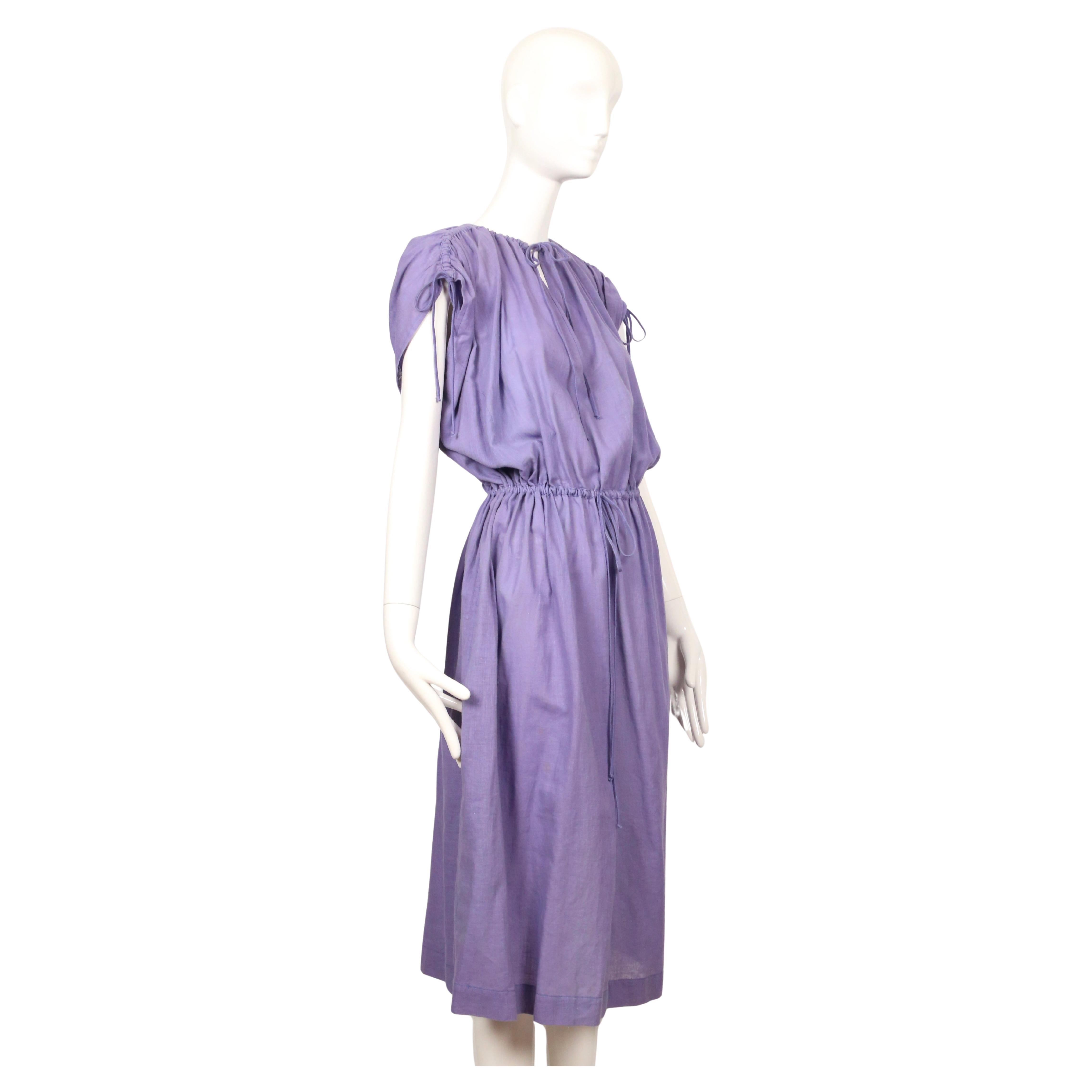 Das Kleid wurde in den 1970er Jahren von Yves Saint Laurent entworfen und ist aus weichem, luftigem Baumwollgaze-Material in einem lilafarbenen Farbton gefertigt. Das Kleid hat eine entspannte, mühelose Silhouette mit einem gerafften Halsausschnitt,