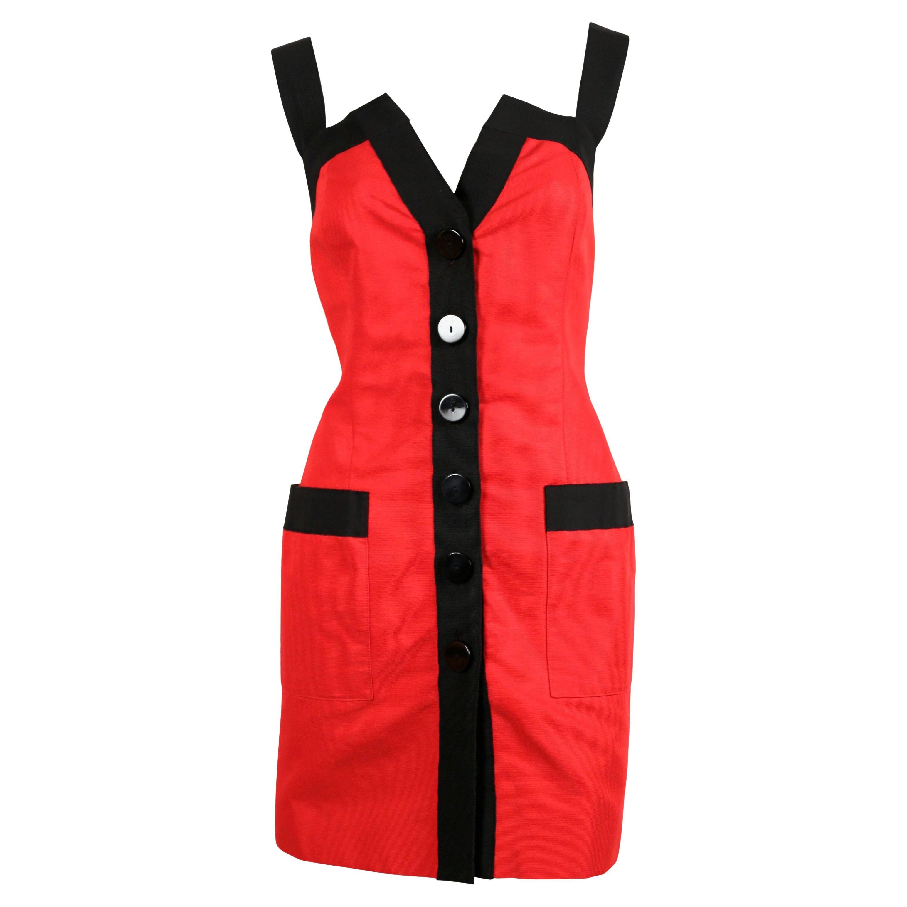 Cette mini robe Saint Laurent Rive Gauche, datant des années 1990, présente un corps d'un rouge éclatant, rehaussé d'un ruban noir en gros-grain. Le modèle comprend de larges bretelles, un décolleté en V profond et une patte de boutonnage ornée de