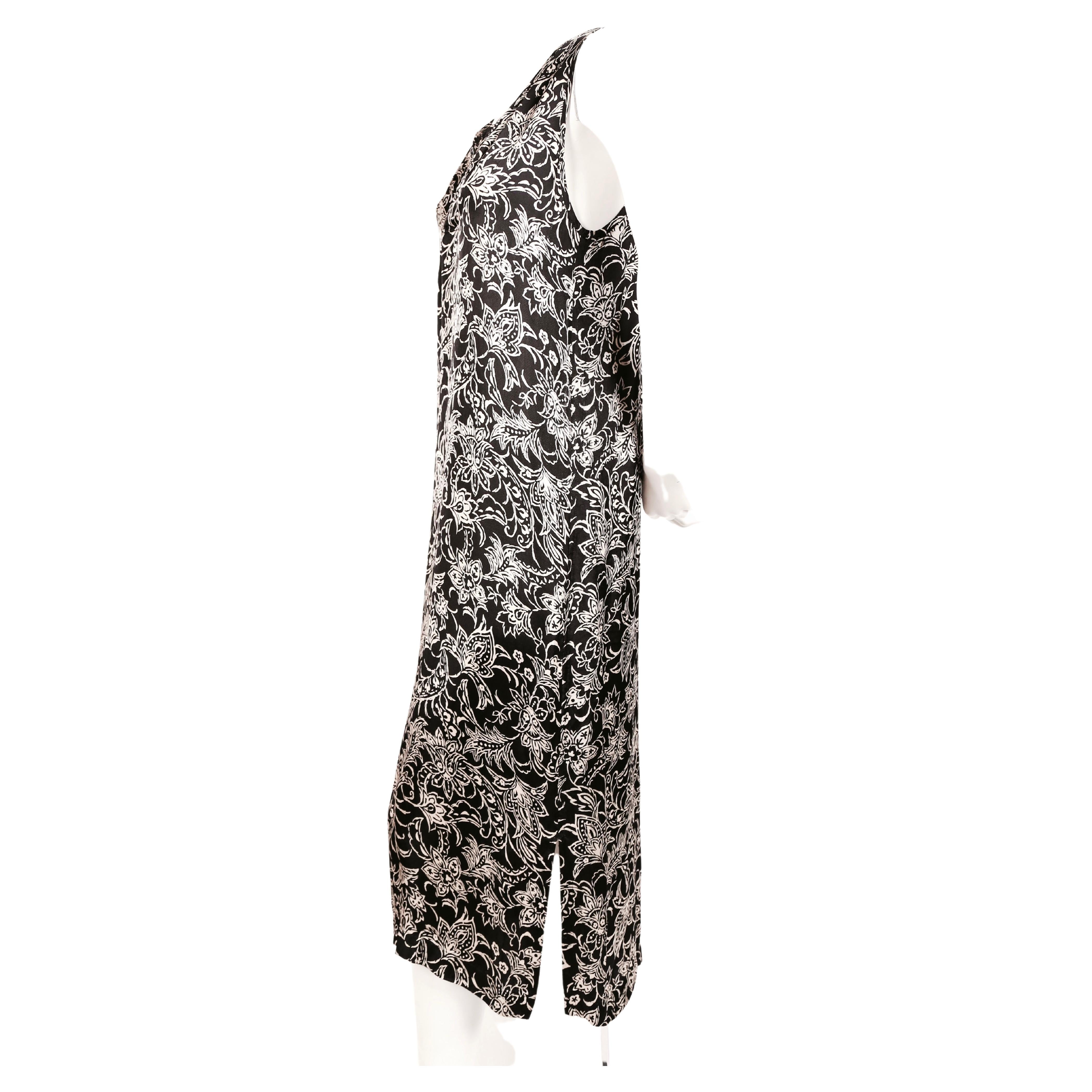 Black and off white abstract printed dress with dual slits and button neckline designed by Rei Kawakubo for Comme Des Garcons robe de chambre. Best fits a size S. Approximate measurements: bust 36