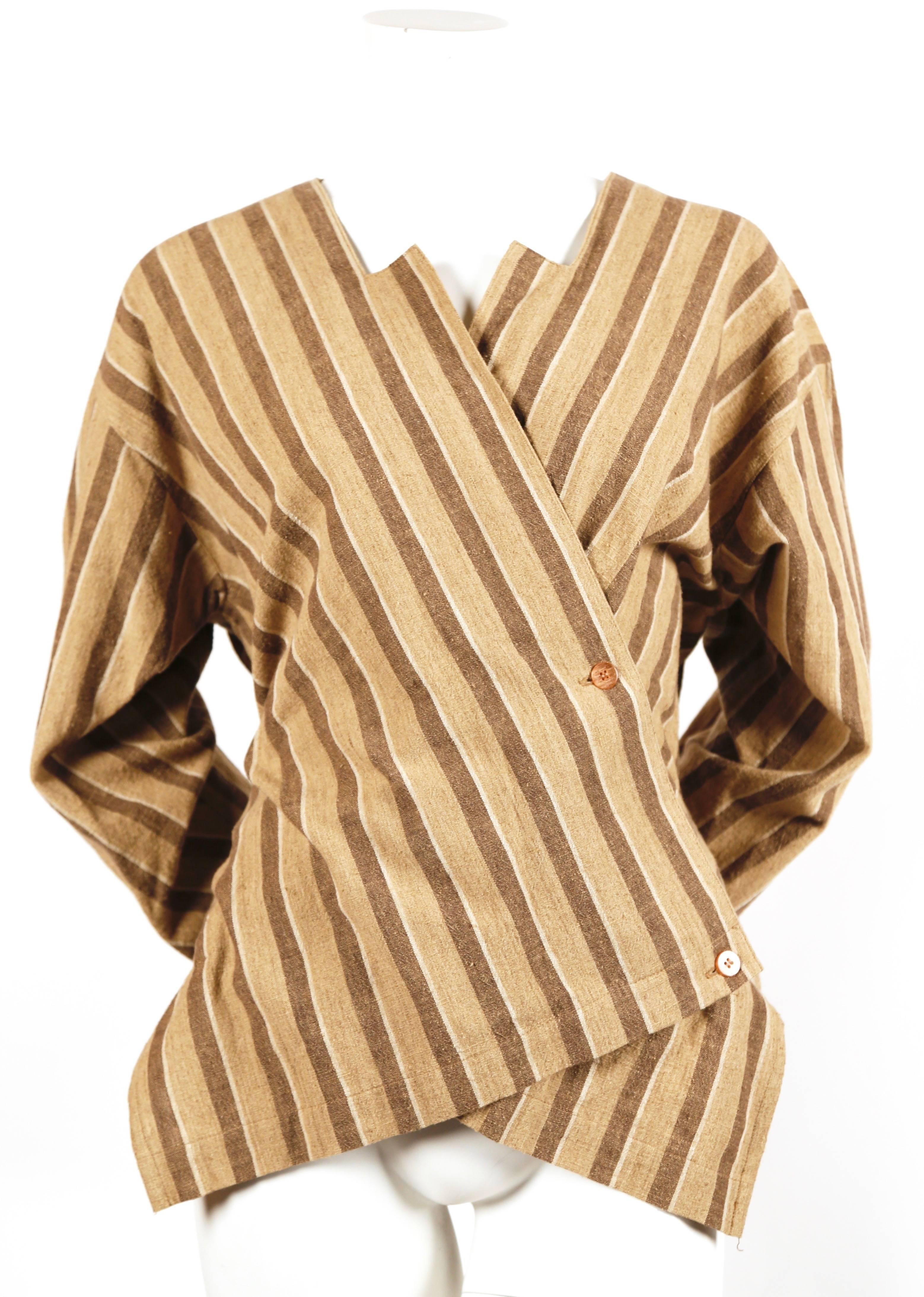 Brown and tan striped cotton jacket with asymmetrical front designed by Issey Miyake dating to the late 1980's. Labeled a size 'S'. Approximate length at shortest point is 24