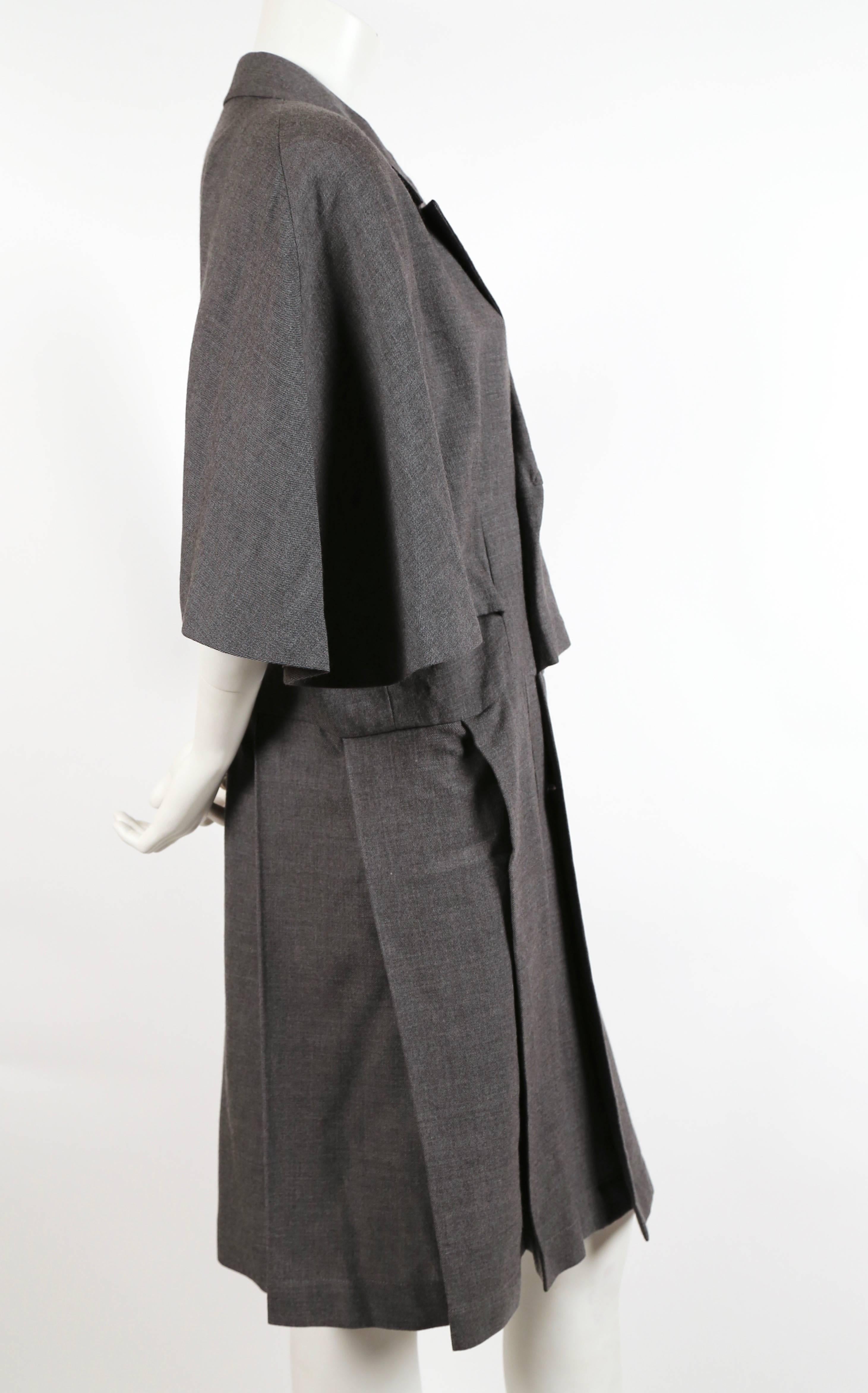Very rare charcoal wool cape coat dress designed by Rei Kawakubo for Comme Des Garcons dating to the 1980's. Can be worn as a coat or dress. Size 'S'. Approximate measurements: bust open, waist 37