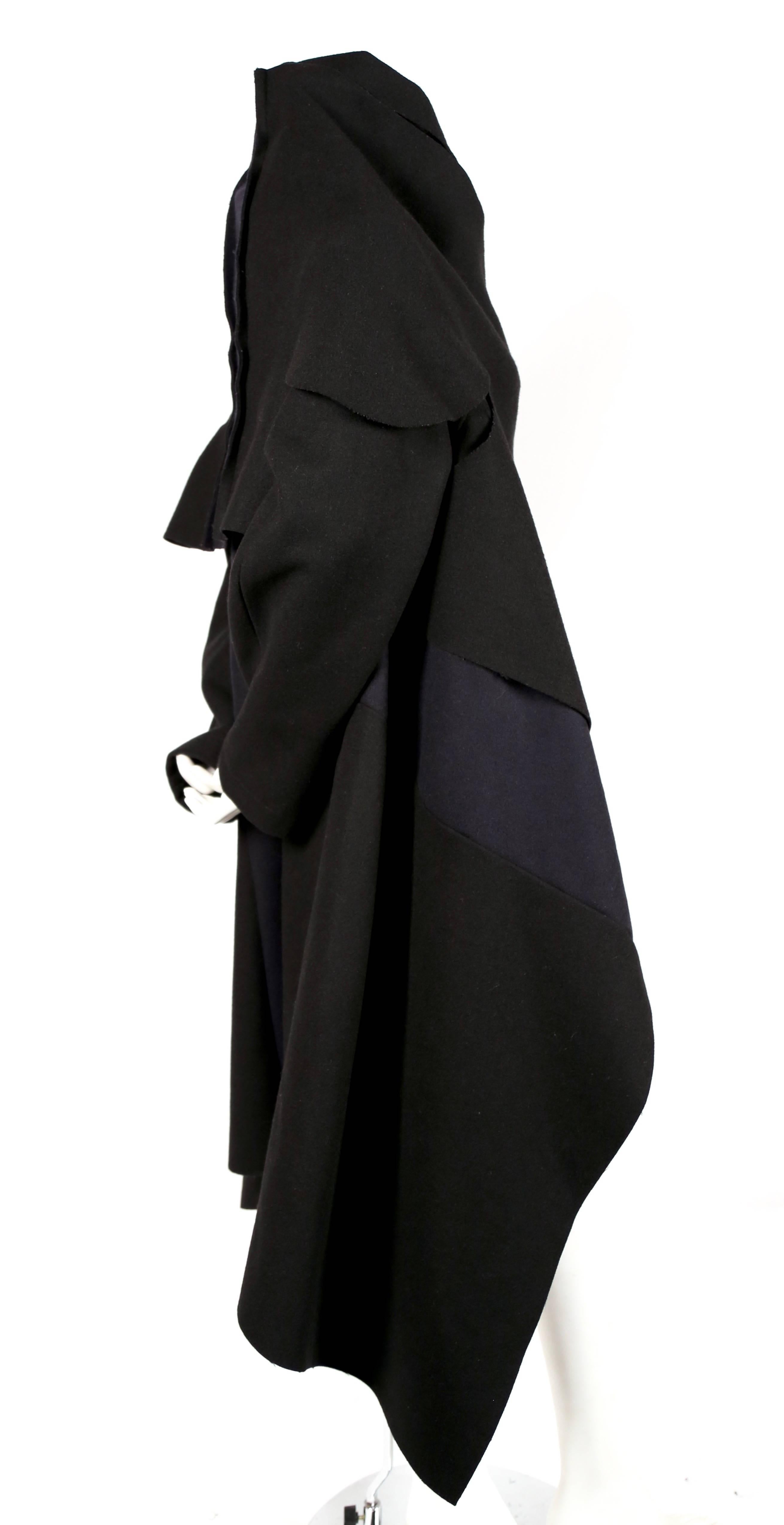 Jet black and navy blue felted wool patchwork coat with draped neckline designed by Comme Des Garcons dating to fall of 2003. Great transitional piece. Can be worn a number of ways. No size indicated. Due to the oversized cut and lack of closures