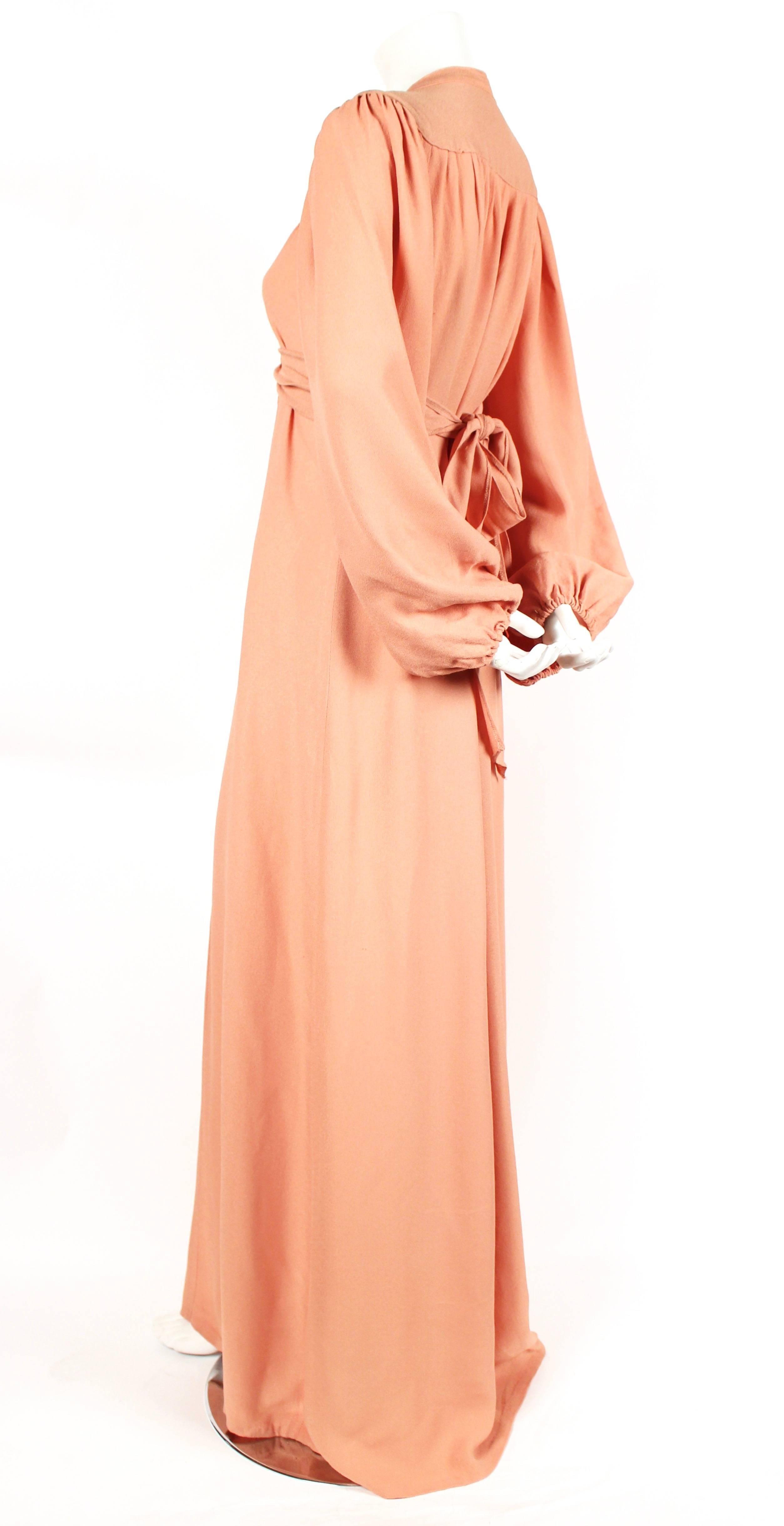 Salmon moss crepe maxi dress with billow sleeves, empire waist and neck tie designed by Ossie Clark dating to the 1970's. No size is indicated however this will fit many sizes due to the loose cut with adjustable waist tie. Approximate measurements: