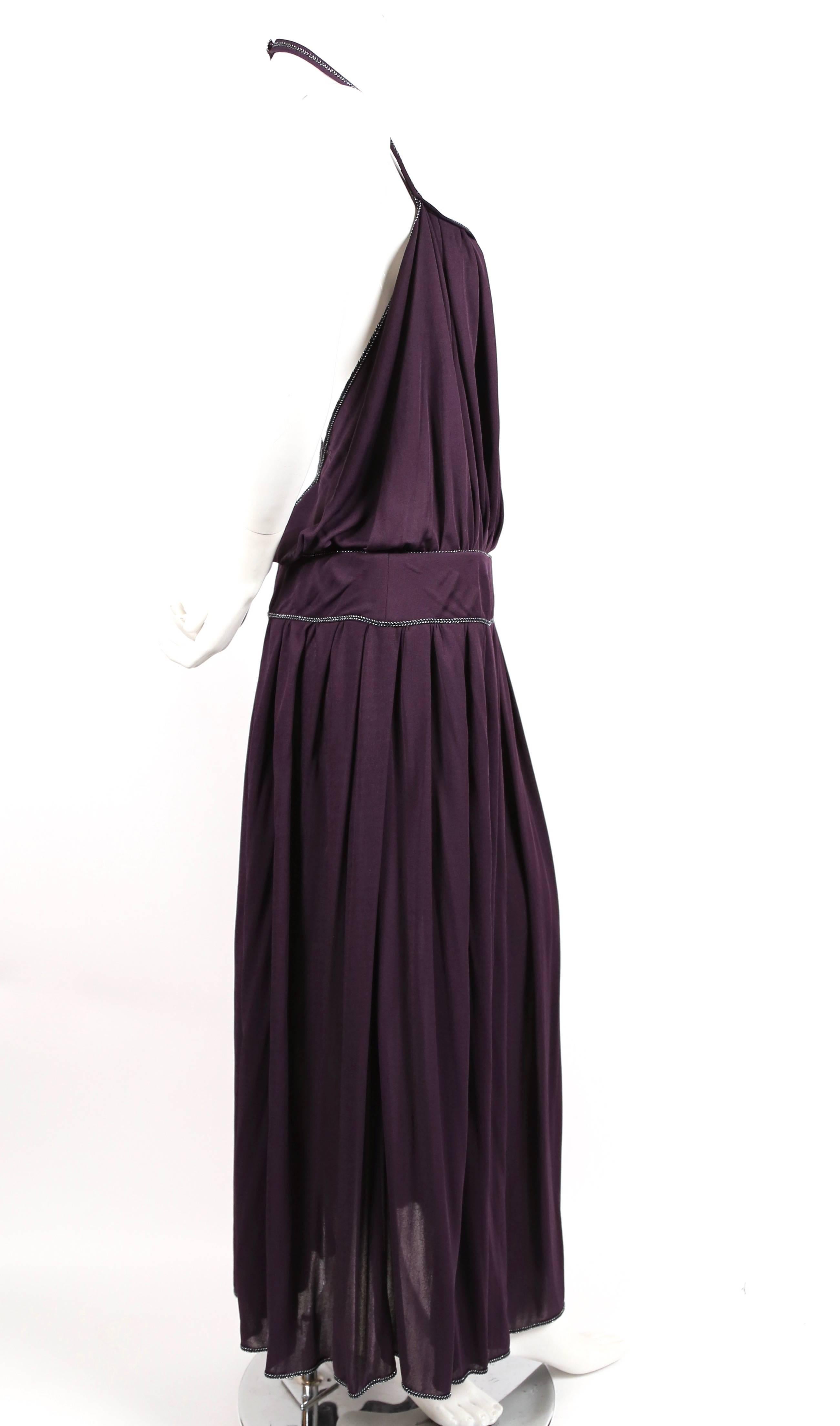 Purple viscose jersey gown with metallic silver toned trim and extra high thigh slit from Bill Gibb dating to the 1970's. Blouson bodice. Halter neckline with decorative button at back of neck. Dress is labeled a UK 12 (US 8) however its fits a US