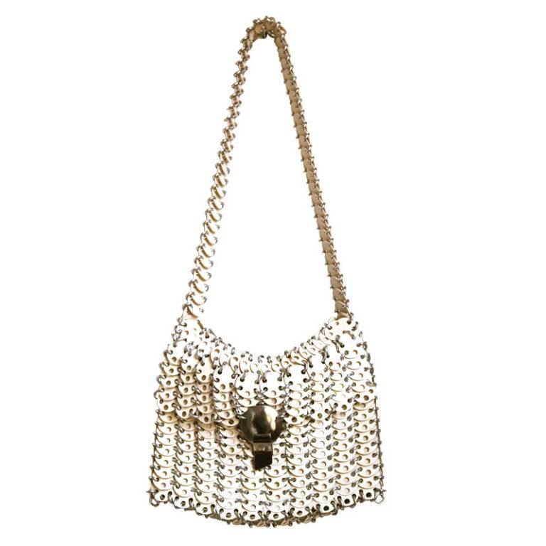 Very rare cream disc shoulder bag with silver toned hardware from Paco Rabanne dating to the 1960's. Bag has an interesting shape when worn on the shoulder.  Bag measures 9