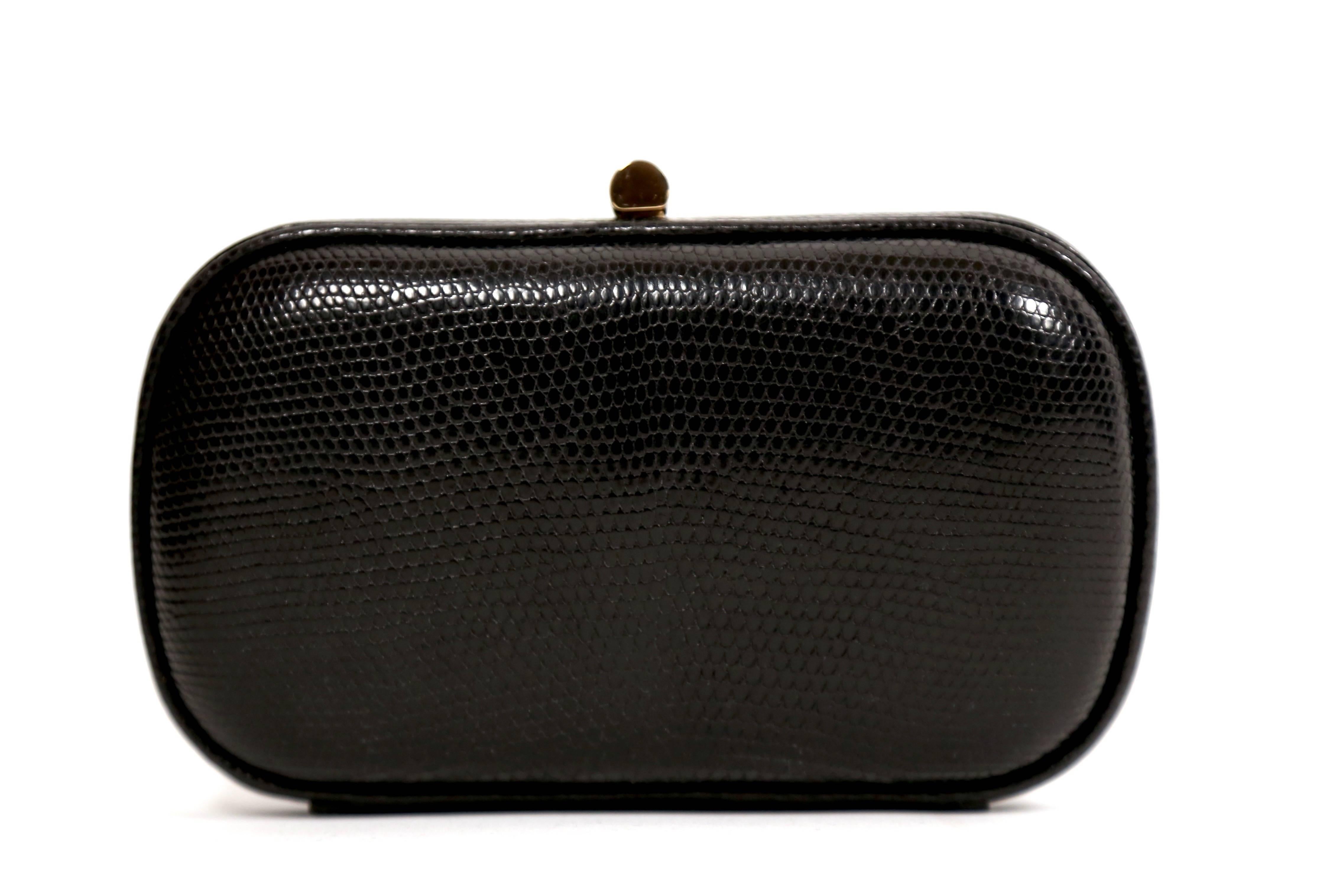 Black karung lizard clutch with gold-toned hardware, black satin lining and push-lock closure designed by Bottega Veneta dating to the 1980's.  Approximate measurements: 6.25
