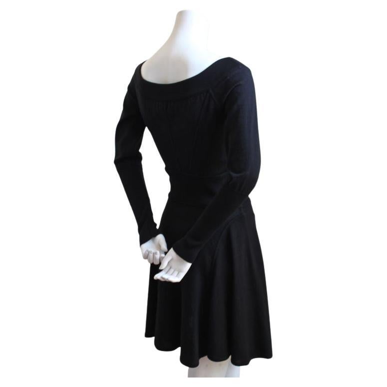 Jet black wool dress with boat-neckline, set in waistband and seamed skirt from Azzedine Alaia dating to the 1990's. Slips on over the head. Dress fits a size small. Approximate measurements: bust 32