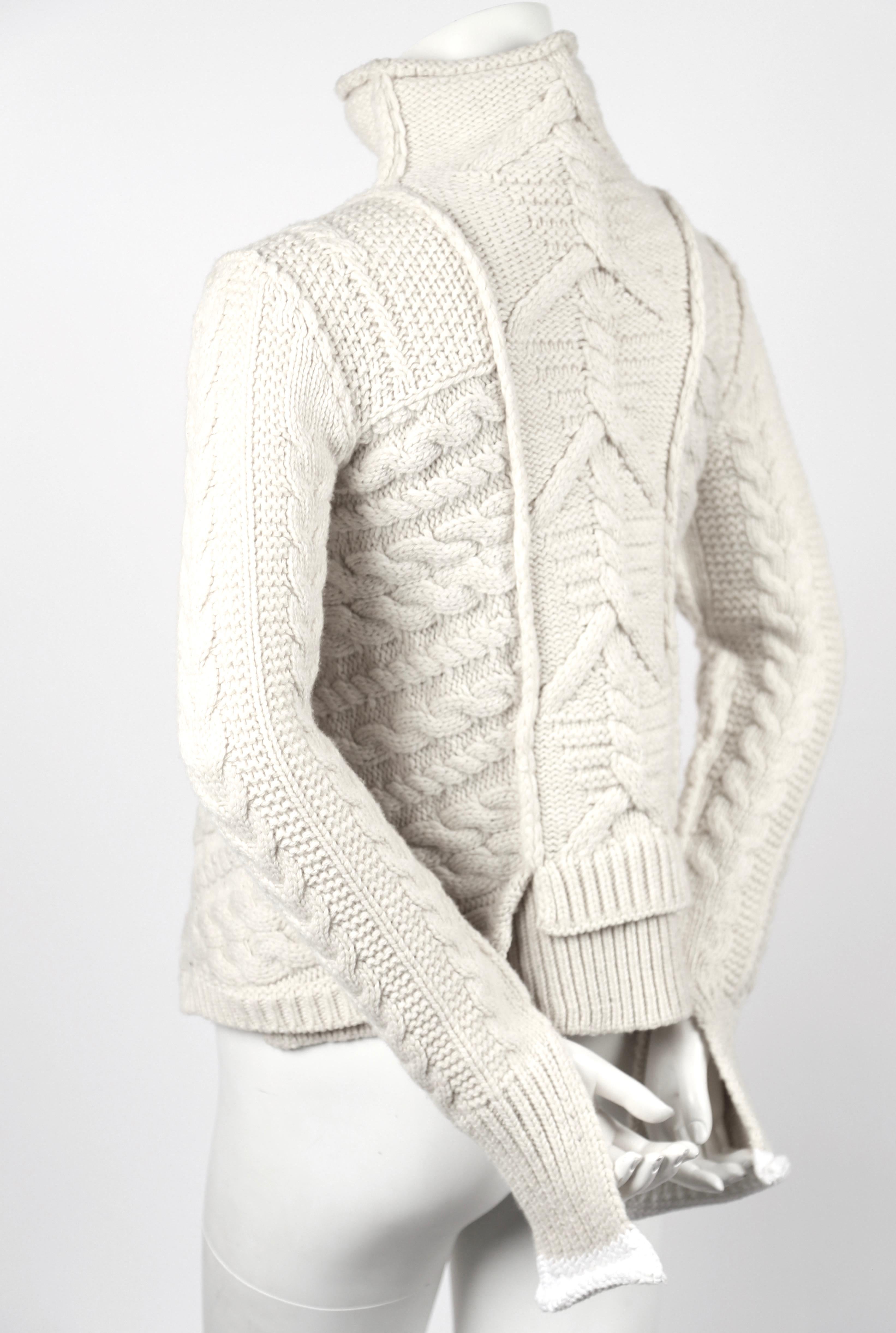 Very rare cream cable knit sweater with asymmetric hemline designed by Phoebe Philo for Celine dating to Fall of 2011. Labeled a size 'M' however this sweater runs small and best fits a size extra-small or small. Approximate measurements