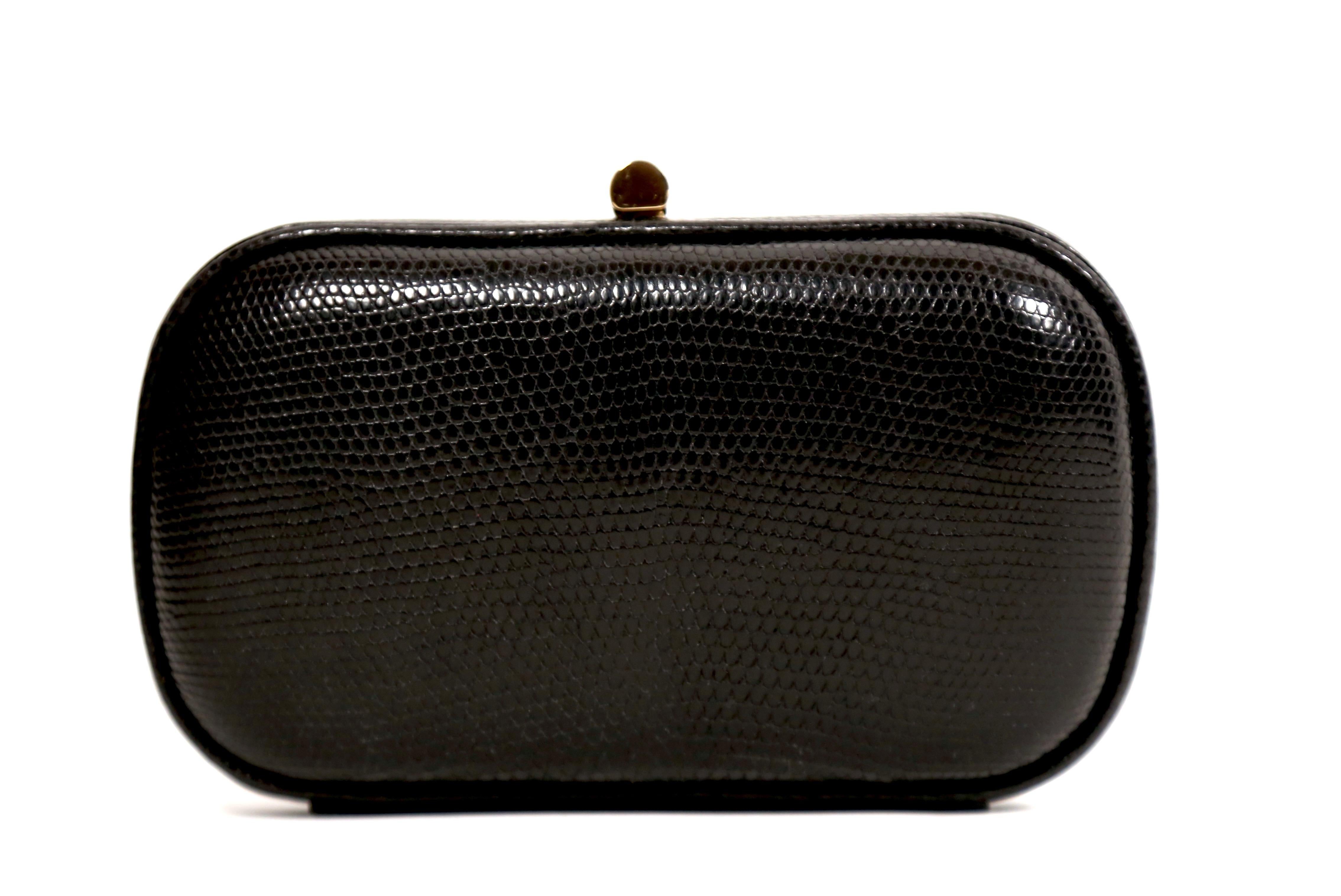 Black karung lizard clutch with gold-toned hardware, black satin lining and push-lock closure designed by Bottega Veneta dating to the 1980's. Approximate measurements: 6.25