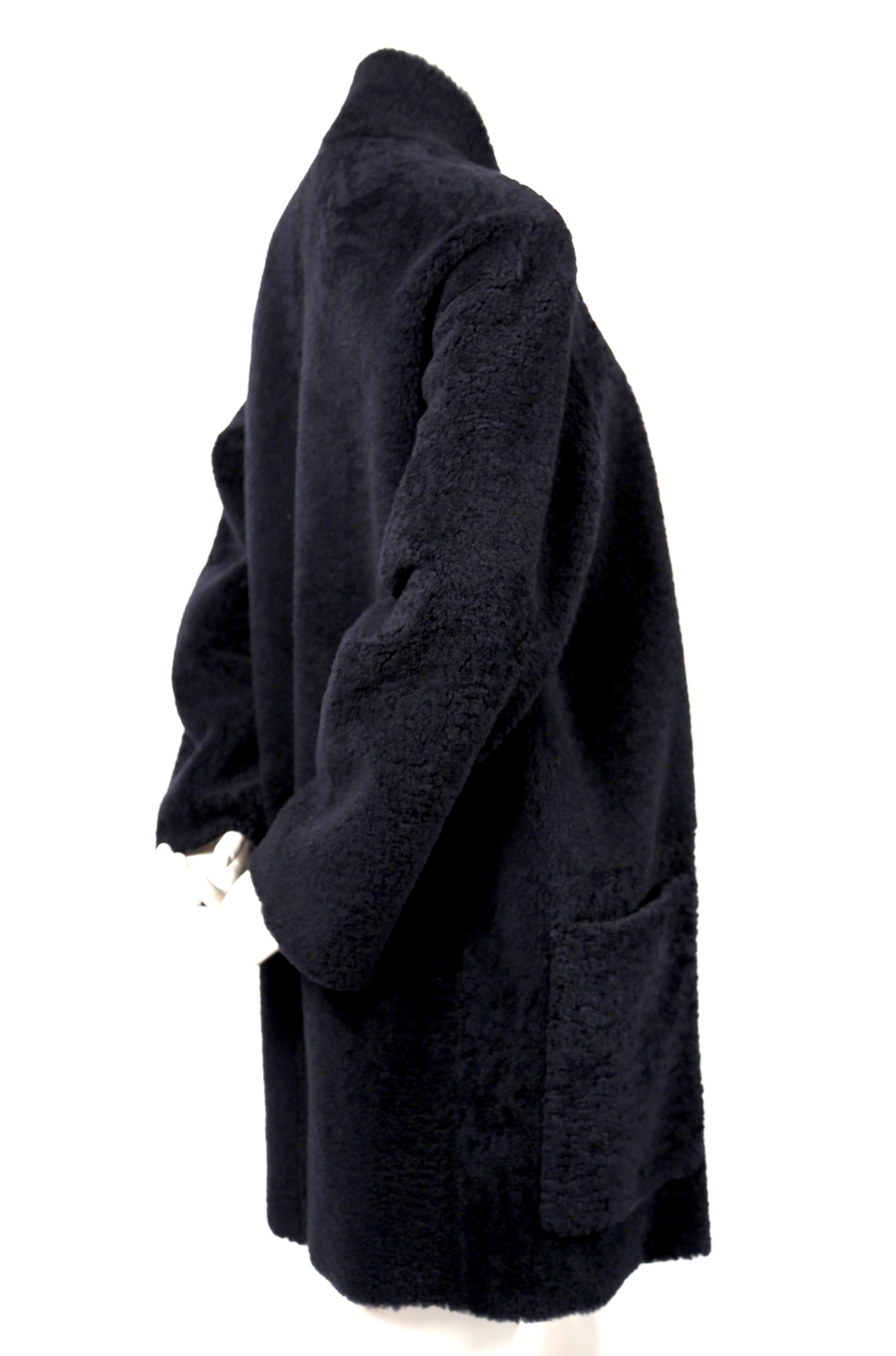 Deep, navy blue shearling coat with open closure designed by Phoebe Philo for Celine. French size 36. Approximate measurements: drop shoulder 21