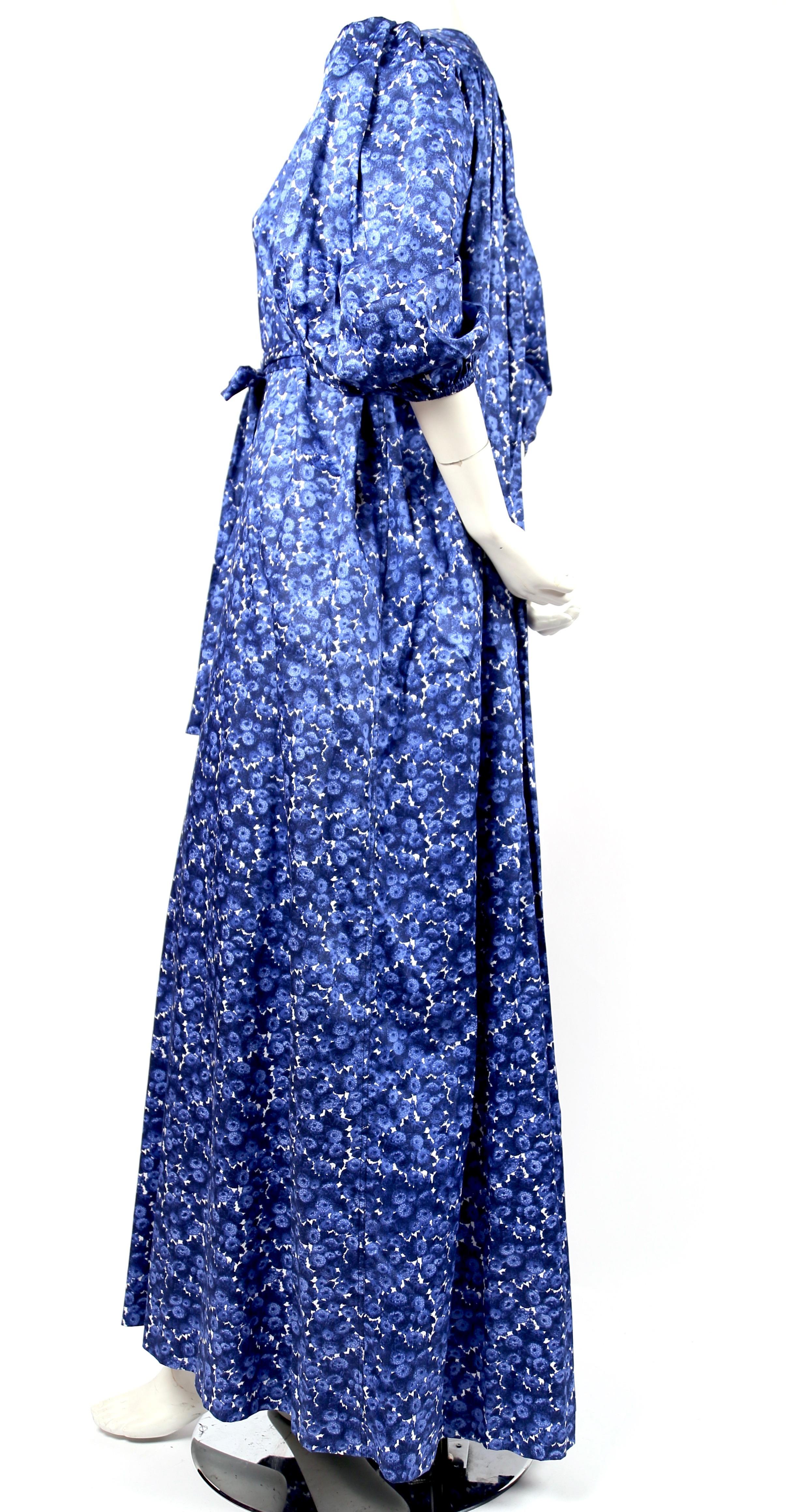  Vivid, blue floral printed, cotton maxi dress with belt designed by Yves Saint Laurent dating to the 1970's. Labeled a French size 36. Approximate measurements: shoulder 13