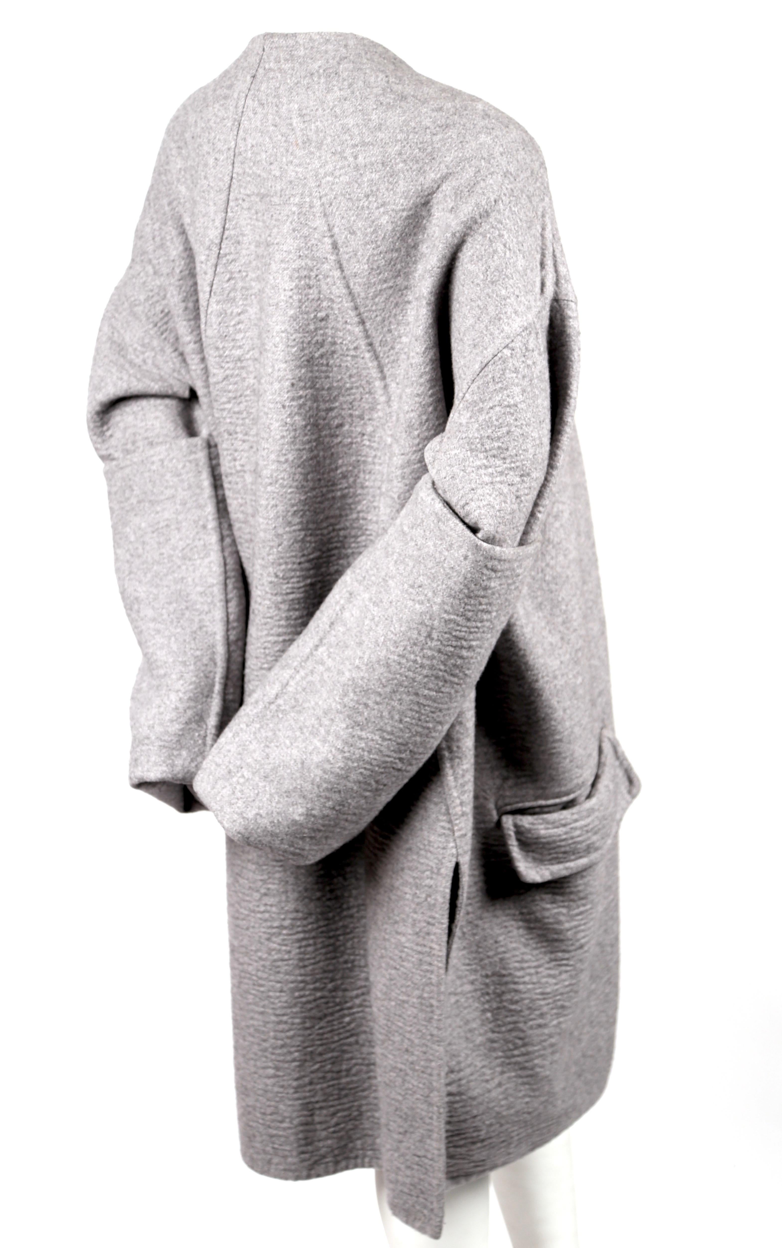 Very rare, grey, double-faced, cashmere coat with exaggerated long sleeves designed by Phoebe Philo for Celine exactly as seen on the runway. Underneath the arms, there are openings to slide arms through so sleeves can be knotted at front as shown