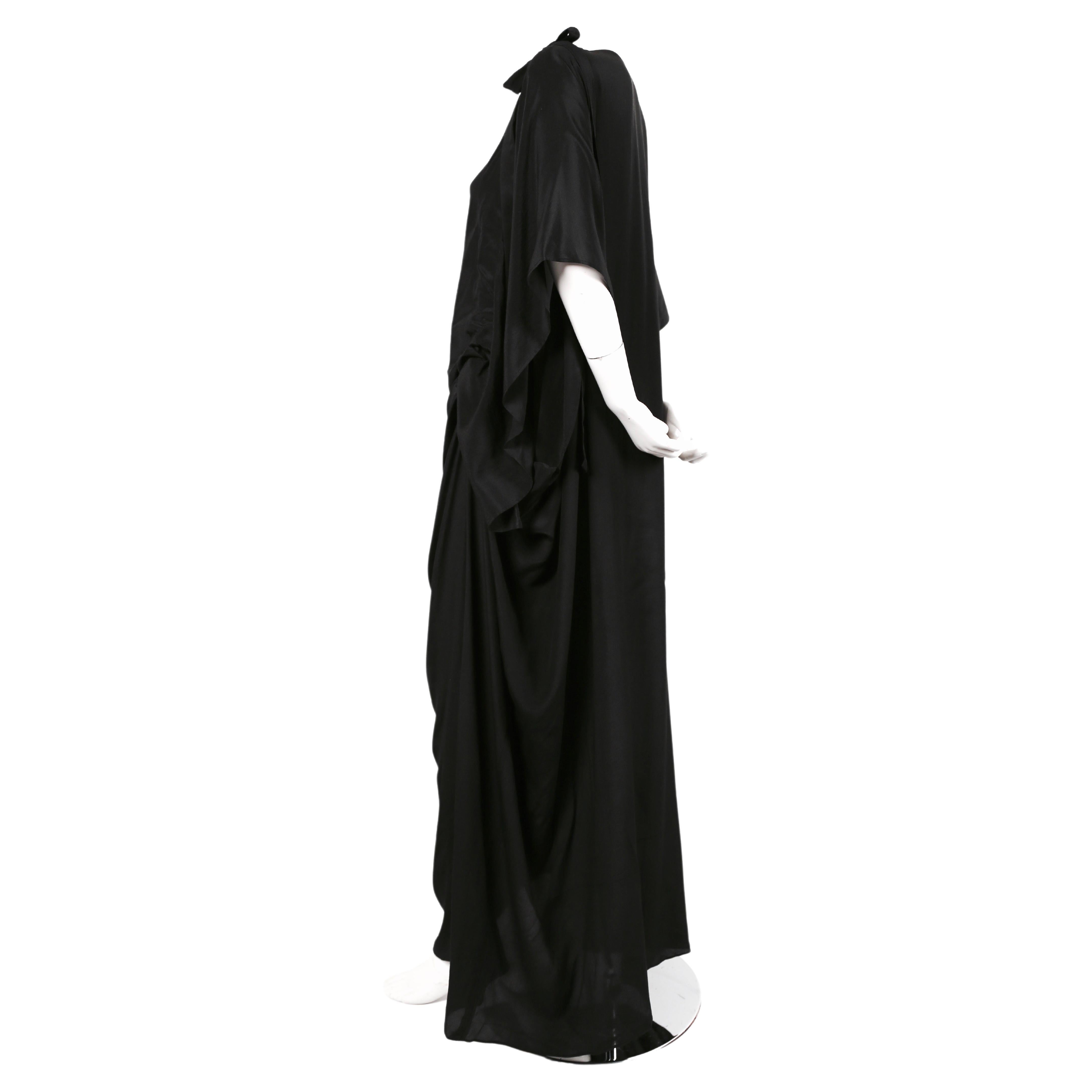 Rarísimo e inusual maxi vestido de seda negra con detalle fruncido diseñado por Kenzo Takada para Kenzo Jap que data de la década de 1970. Los lazos permiten acortar o alargar el vestido y crean una bonita caída. Etiquetada como talla francesa 