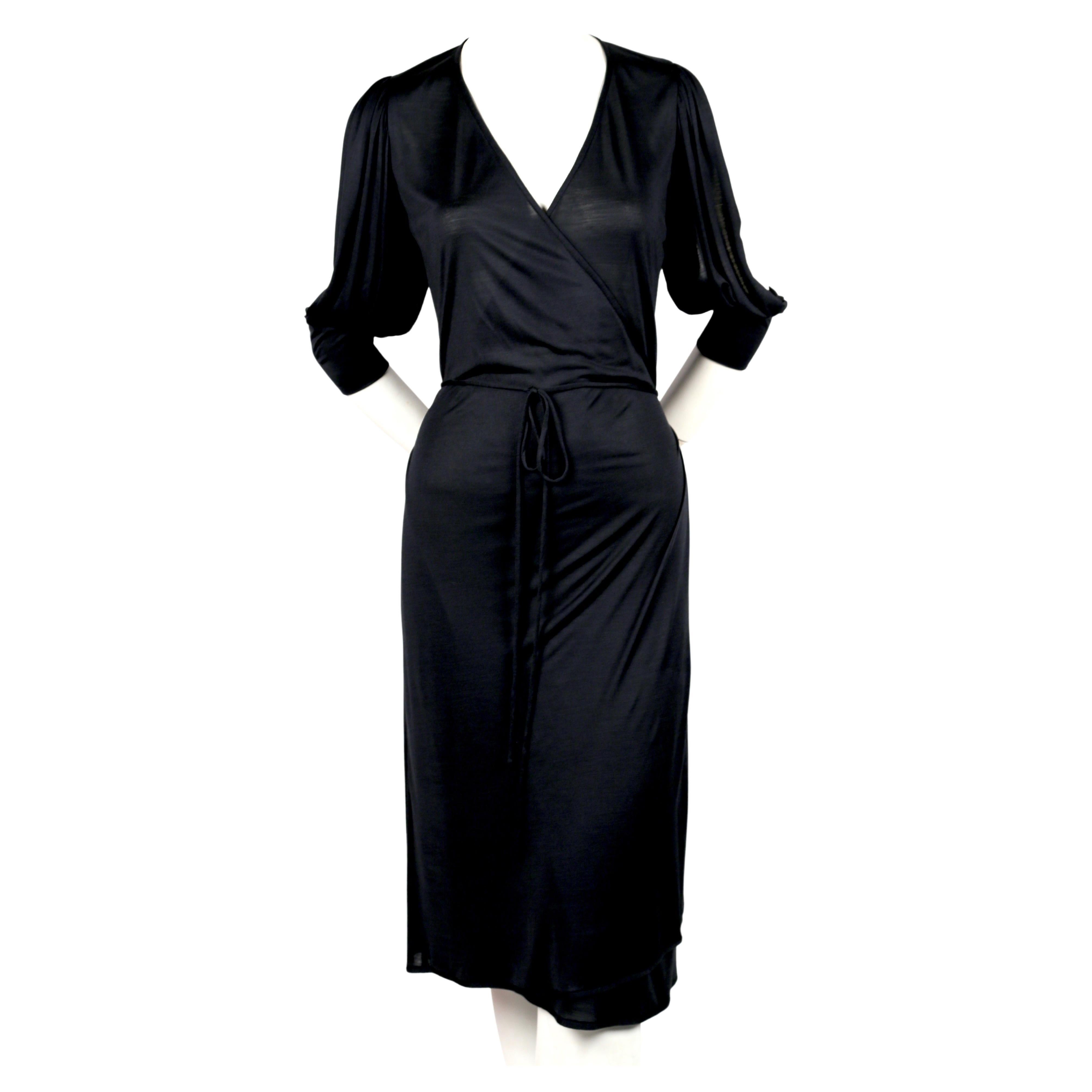 Inky blue-black jersey, wrap dress designed by Nicolas Ghesquiere for Balenciaga dating to spring of 2000. French size 36. Bust waist and hips are adjustable due to wrap closure however this best fits a French size 36. Approximate measurements: