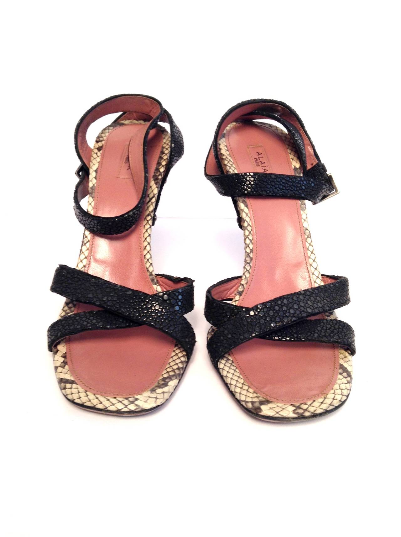 Wear these Alaia wedges day or night! Black straps sit atop a python-covered wedge heel with cool buckle detailing at the back of the heel. Adjustable ankle strap with silver tone hardware. 

Measurements: 4.5