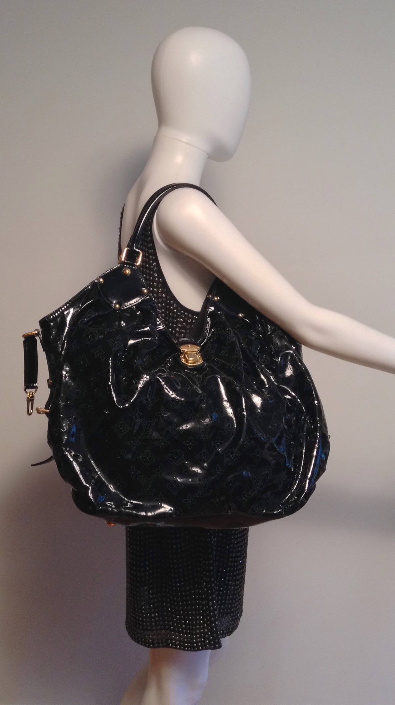 This is an authentic LOUIS VUITTON Surya Mahina XL in Black. This stunning shoulder bag is crafted of Mahina Louis Vuitton monogram perforated patent leather. The bag features rolled patent leather shoulder straps and brass links with a leather