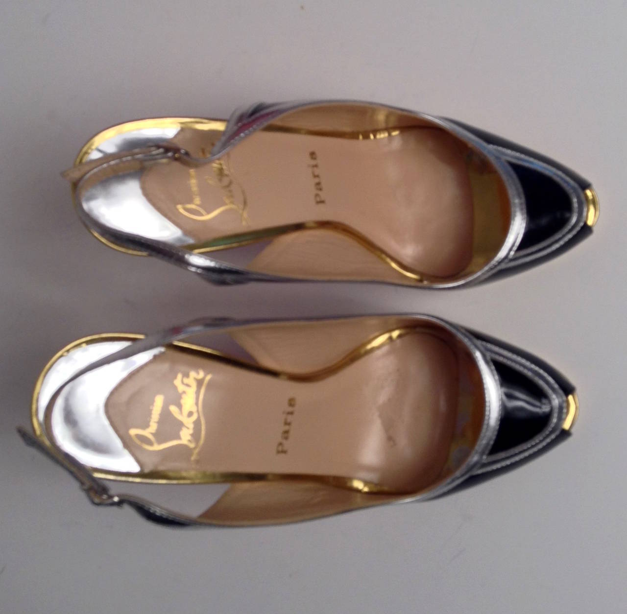 Black patent leather Christian Louboutin slingback peep-toe pumps with metallic silver-tone trim and metallic gold-tone covered platform and heel.

Includes dust bag.

Fits like an 8

In very good condition, minor wear on gold platform and