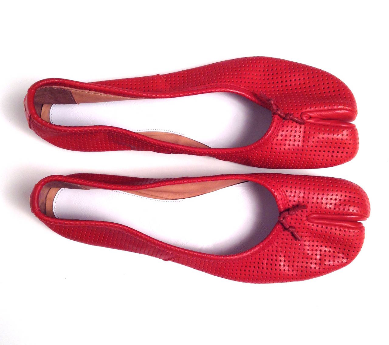 Iconic split toe tabi shoe in a warm cherry red perforated leather.

New and unworn condition.

Comes with individual Margiela shoe bags. Original retail $645
