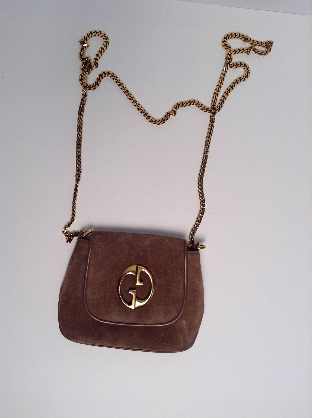 Finish off any evening ensemble with this classic Gucci Taupe Suede Gold Chain shoulder bag. The 1973 Reissue features soft taupe suede with tonal taupe leather finish at the trim. Gold hardware and a long gold chain perfectly decorate the adorable