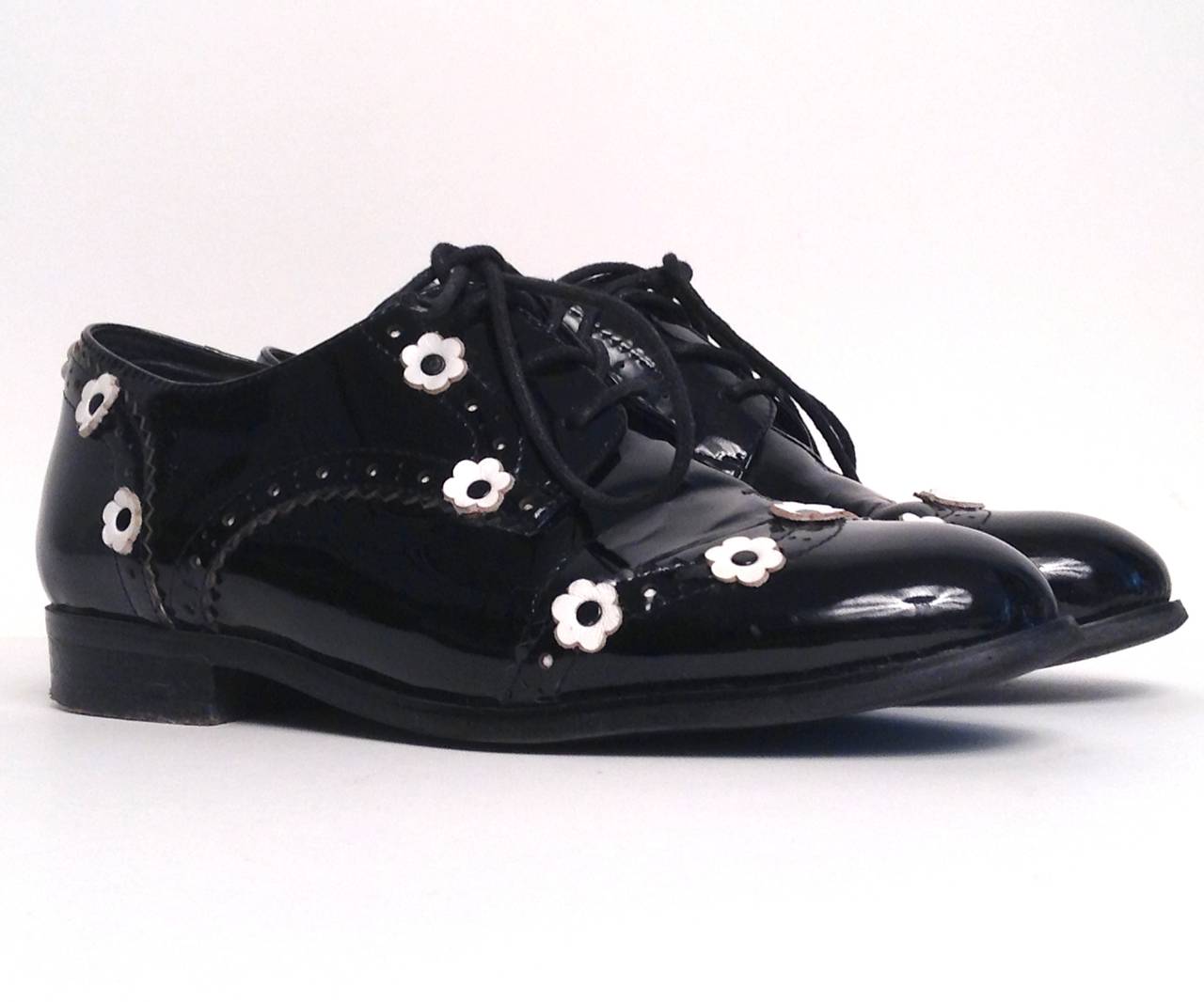 Nothing gets cuter than these Chanel Black Patent Oxfords with Daisies. The lace up Oxfords features black patent upper with white daisy throughout. Rounded toe. Stacked heel. Lace up front. 

Measurements: 1