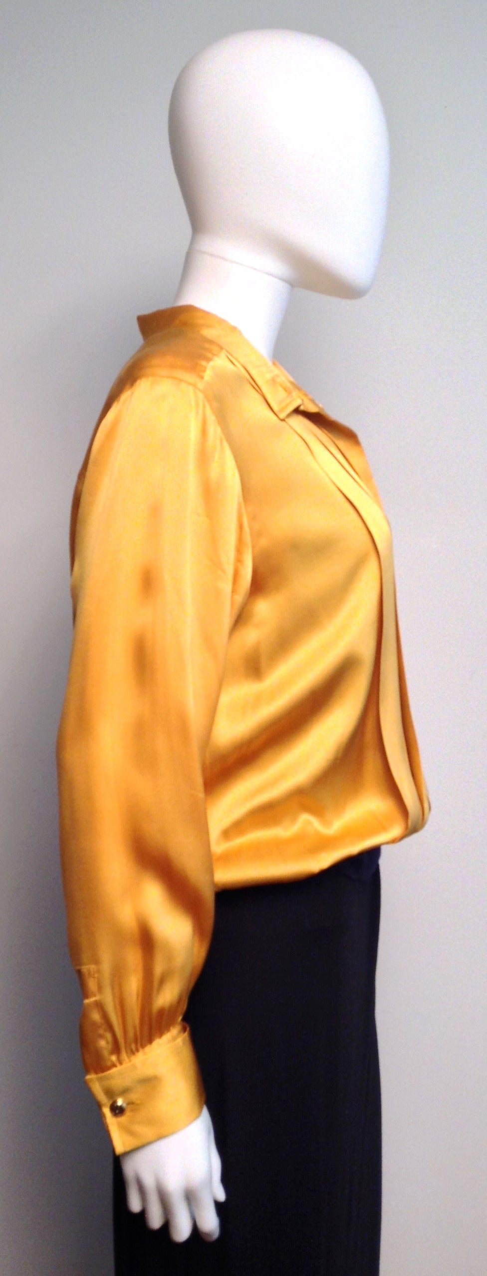 Luxurious yellow silk pleated blouse. 

Hidden button closure. 

Black rib stretch hemline.

Measurements: 38