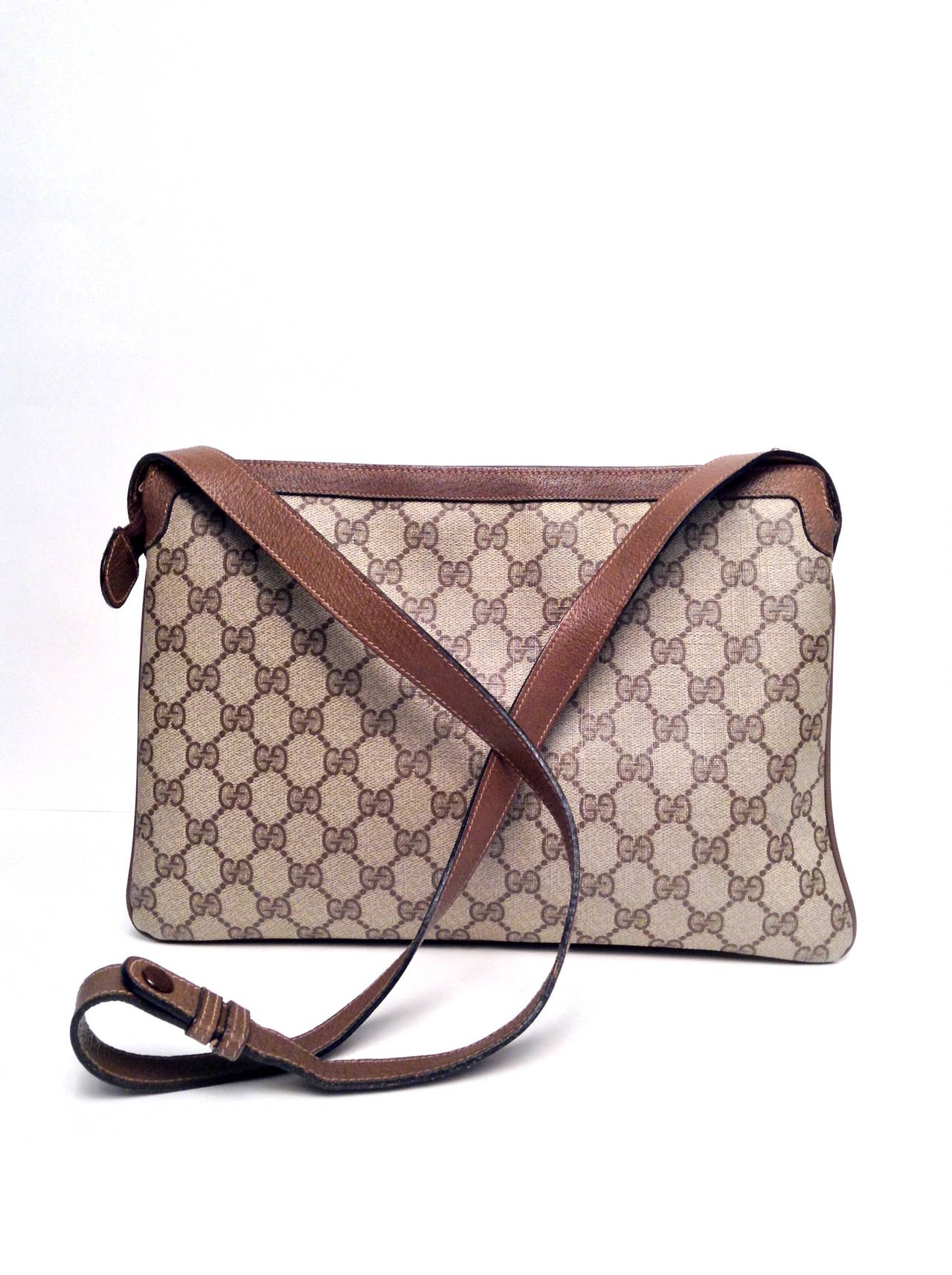 A classic and versatile bag to add to your collection. Exterior features light brown waxed classic monogram canvas with a classic Gucci stripe on the front. One exterior slip pocket sit at the front of the bag. Interior features three compartments