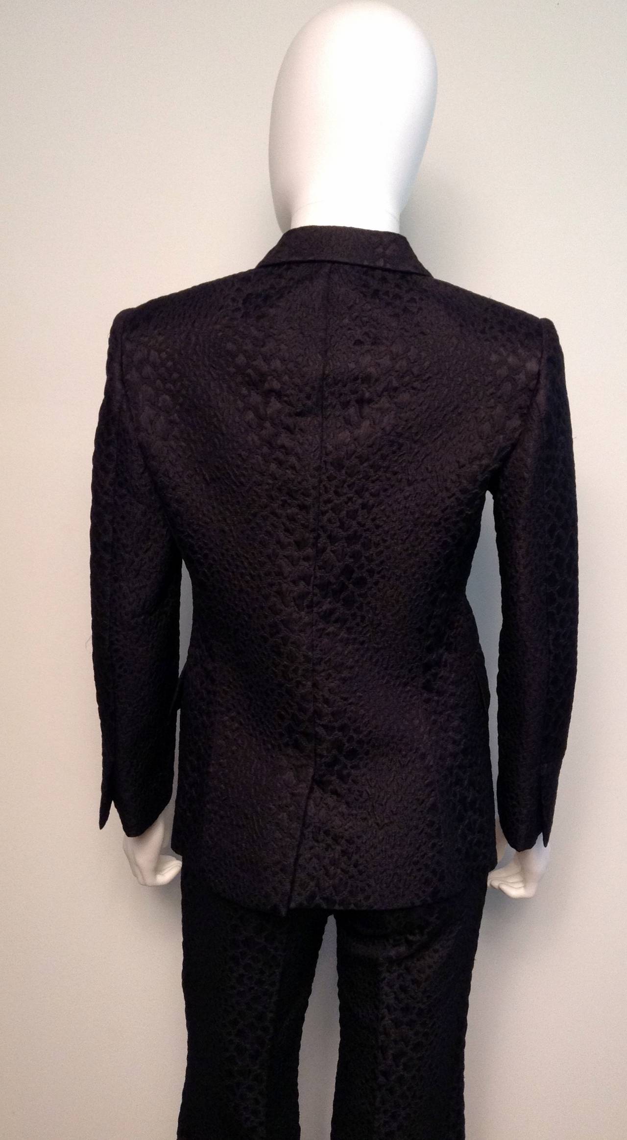 Worn only once by previous owner, an exquisite piece from Tom Ford's SS 2000 collection for Gucci. Features silver jewelled pin. 

One fabric covered black snap closure on jacket.

Pants are high waisted, with a flare leg. 

In excellent
