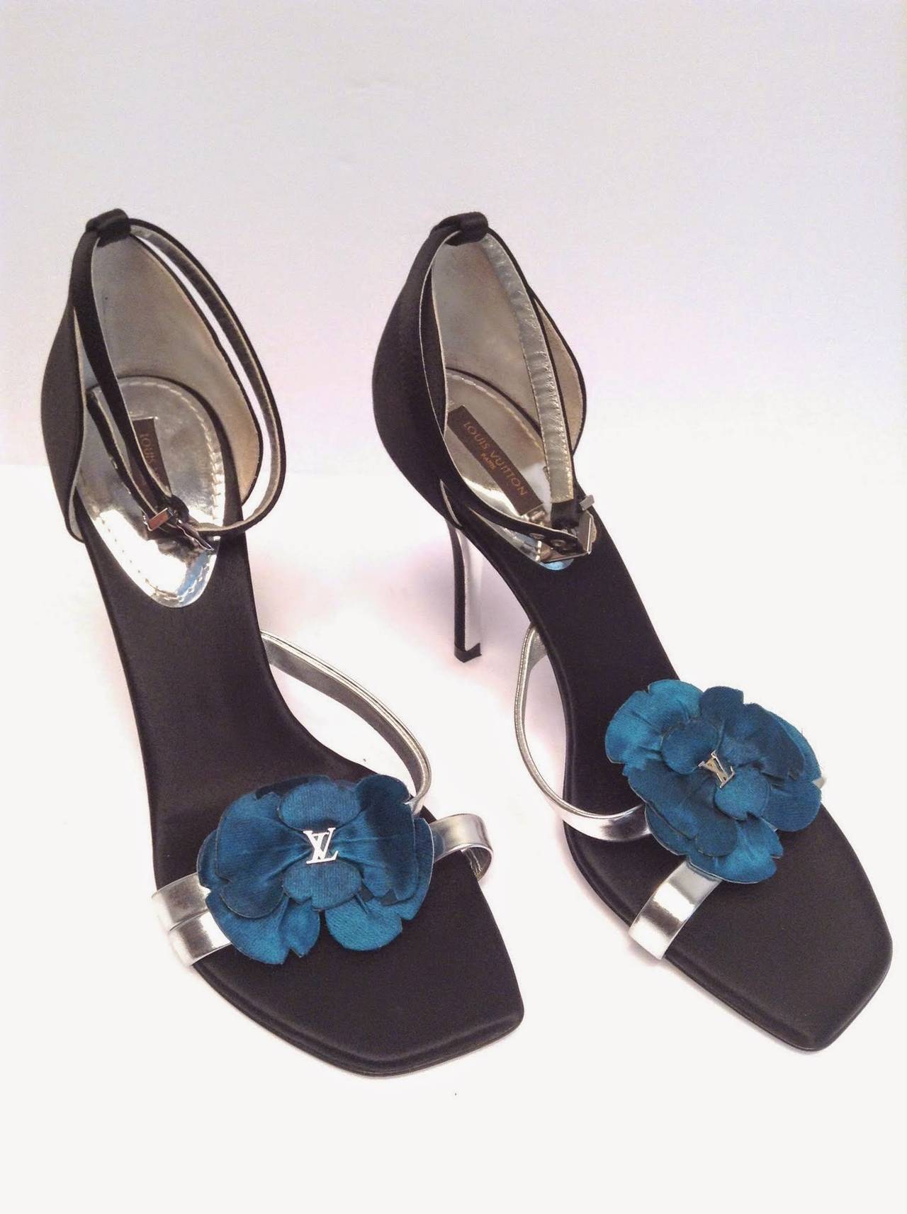 Beautiful black satin sandals with silver leather straps over the toes embellished with teal silk flower petals and silver LV logo. 

Comes with dust bags.

Heel height 3
